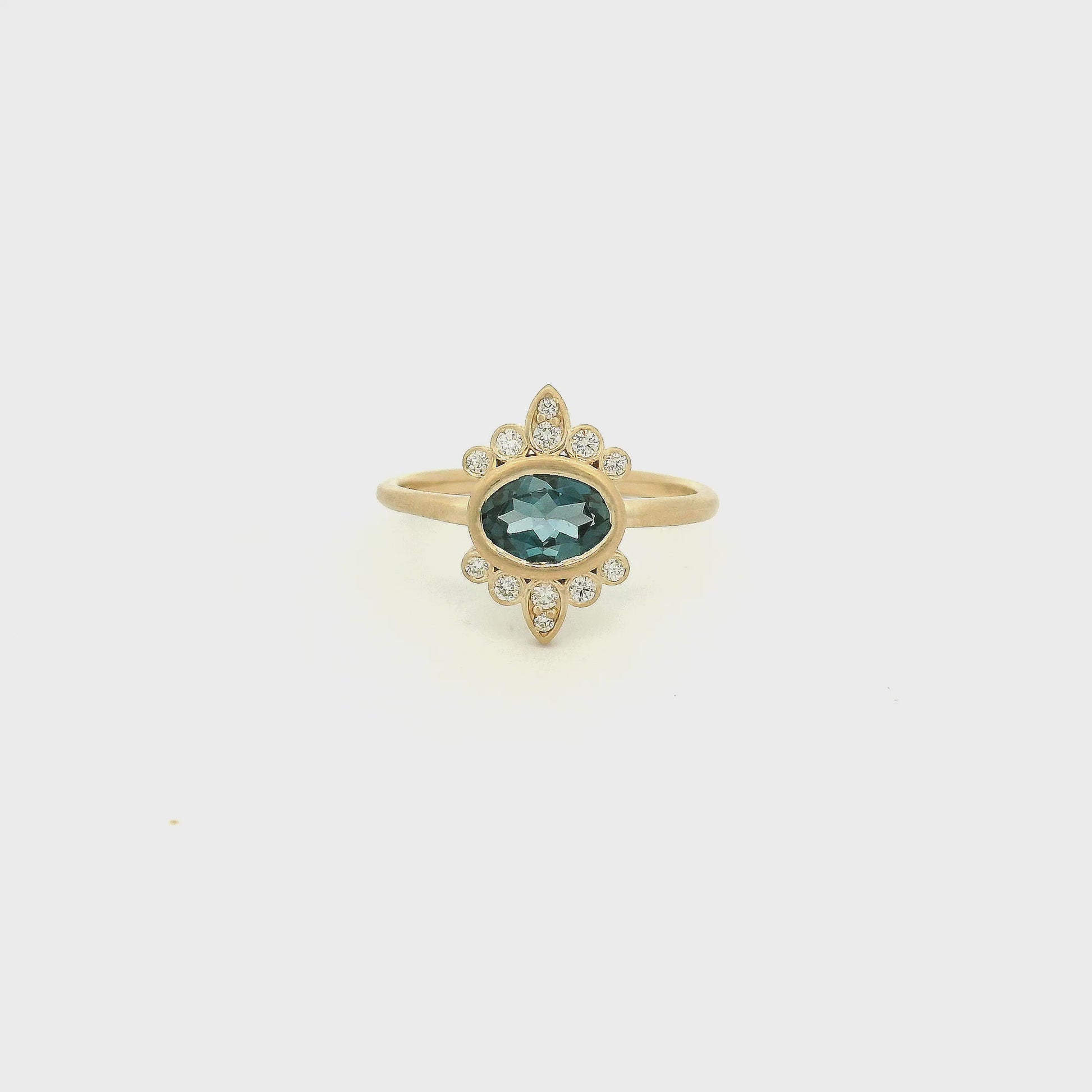 A Yellow Gold Ring with a bezel set oval cut natural London Blue Topaz in the center with diamond bursts at Forever Rox Fine Jewelry, Lake Tahoes Best Jewelry Store
