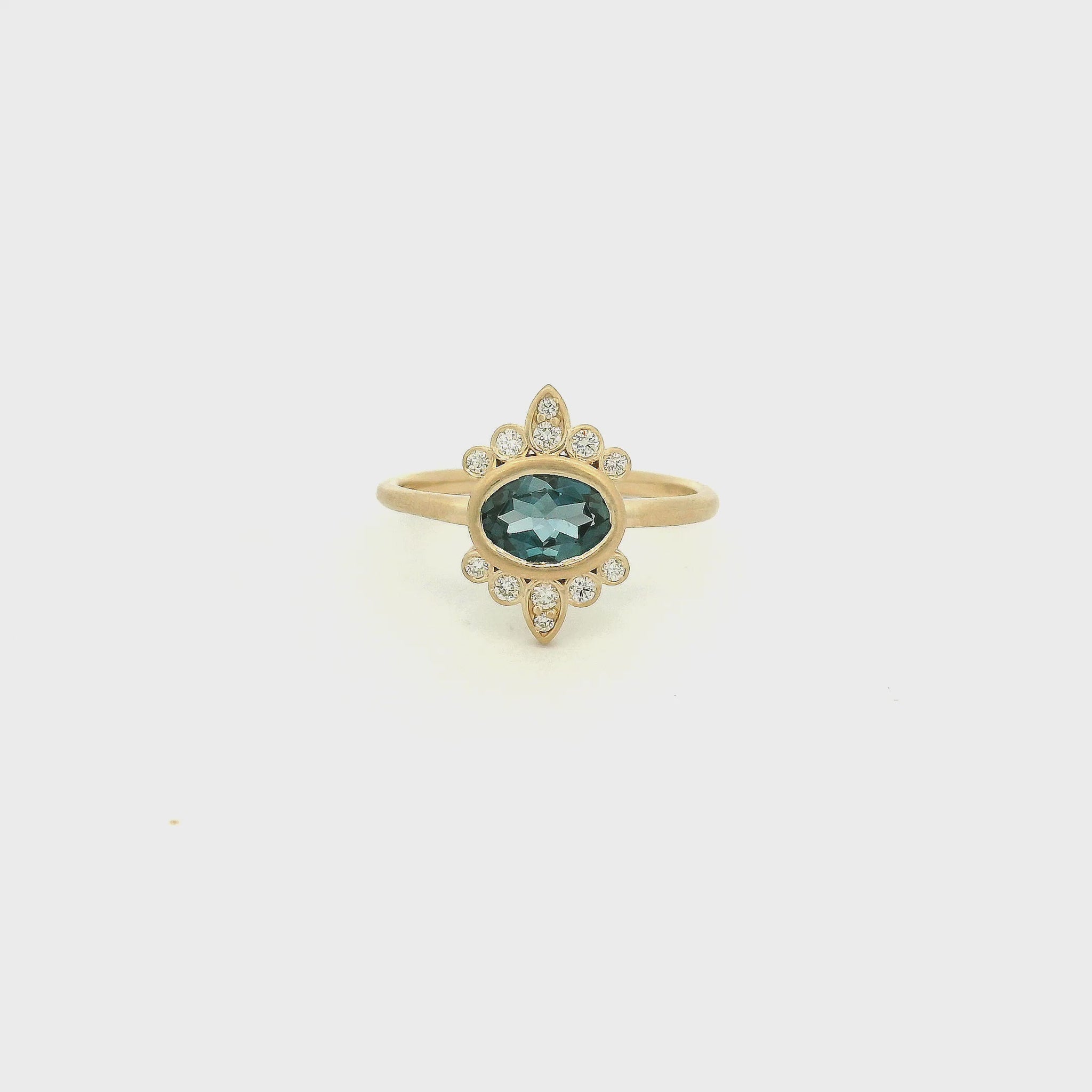 A Yellow Gold Ring with a bezel set oval cut natural London Blue Topaz in the center with diamond bursts at Forever Rox Fine Jewelry, Lake Tahoes Best Jewelry Store
