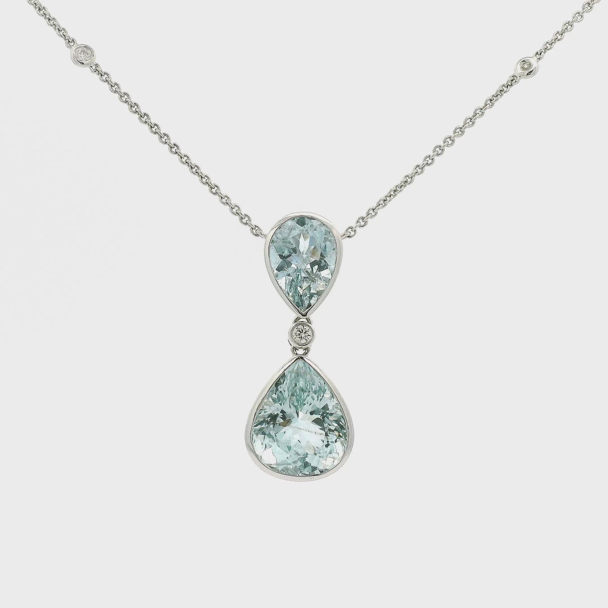 Two Pear shape Aquamarines set in white gold with one diamond dangling from a white gold diamond chain Forever Rox Fine Jewelry