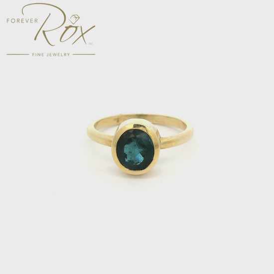 A Yellow Gold Solitaire Ring with a bezel set round cut blue Indicolite Tourmaline in the center at Forever Rox Fine Jewelry, Lake Tahoes Best Jewelry Store