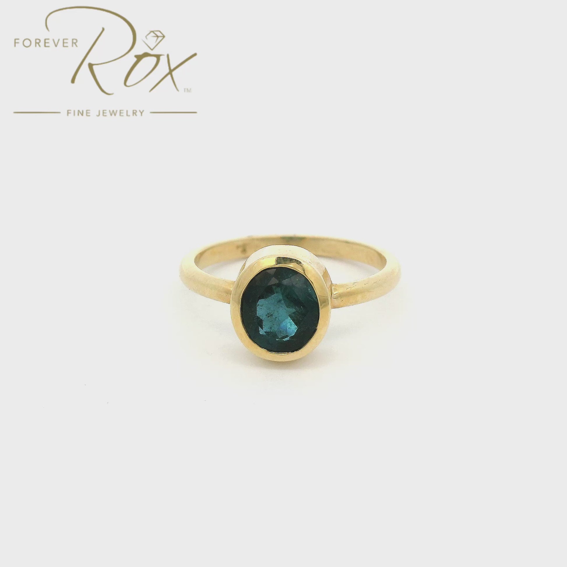 A Yellow Gold Solitaire Ring with a bezel set round cut blue Indicolite Tourmaline in the center at Forever Rox Fine Jewelry, Lake Tahoes Best Jewelry Store