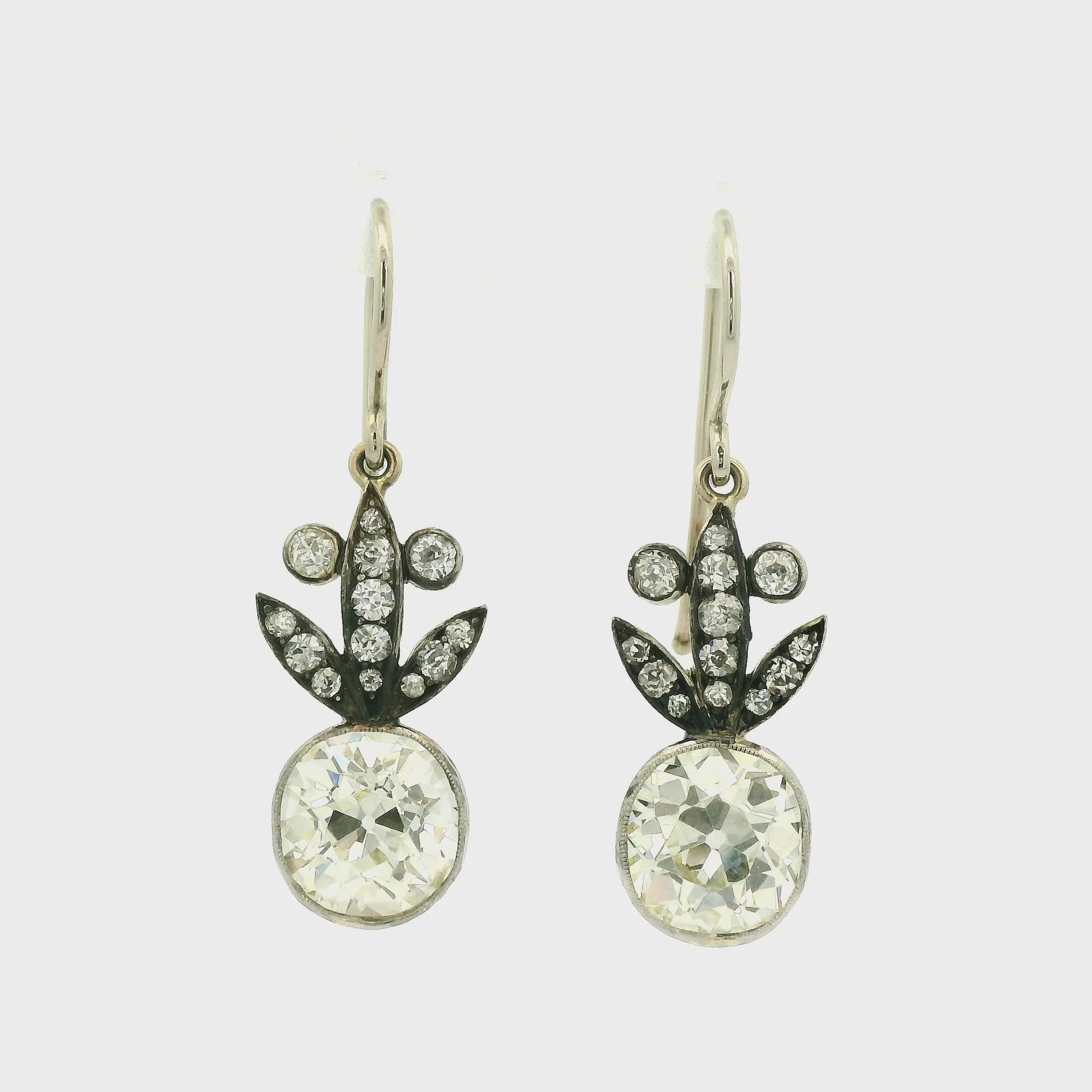 A Pair of White Gold Victorian Dangle Earrings with bezel set old mine cut natural Diamonds in the center with diamonds dangling down at Forever Rox Fine Jewelry, Lake Tahoes Best Jewelry Store