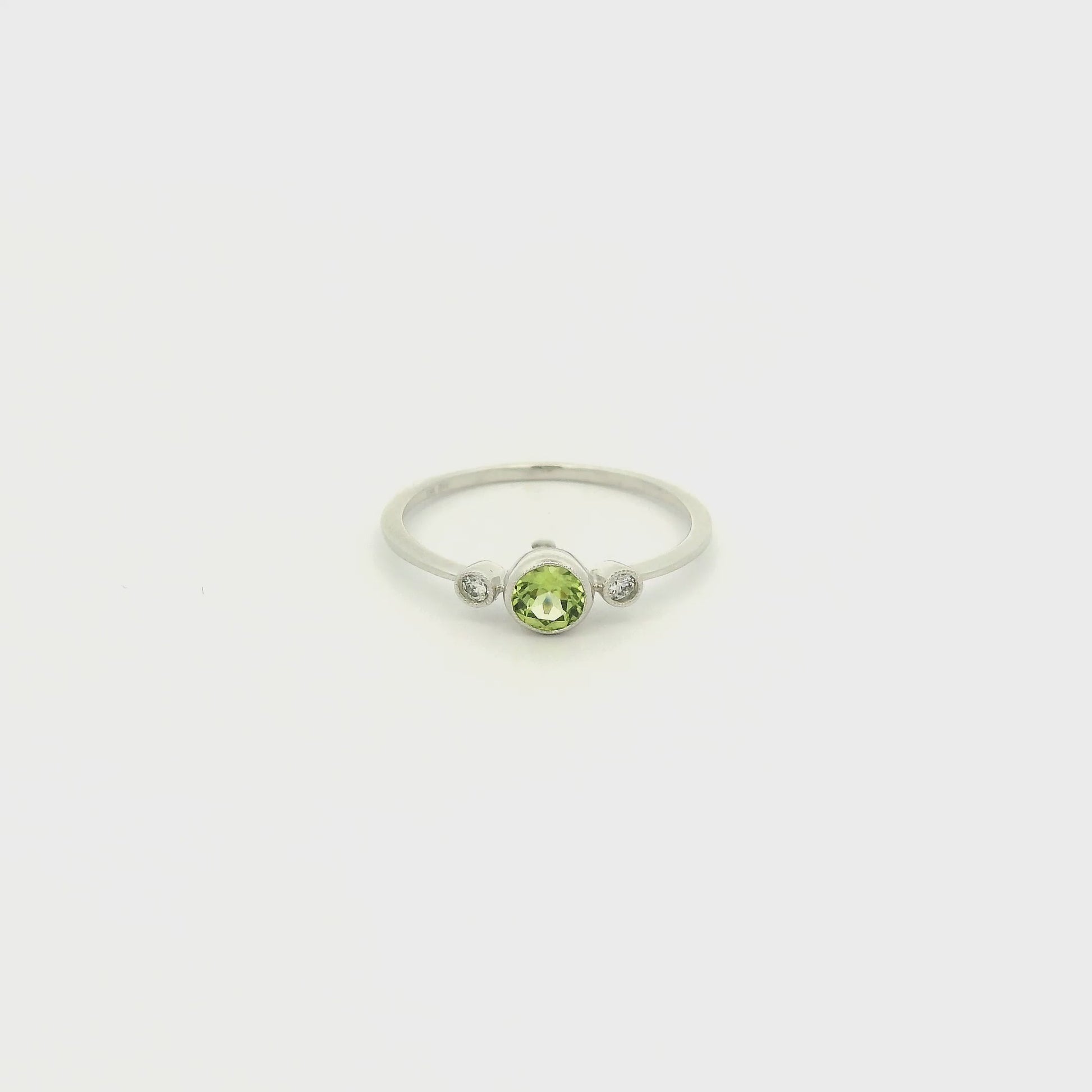 A White Gold Ring with a milgrain bezel set round cut natural Peridot in the center with 2 bezel set Natural Diamonds at Forever Rox Fine Jewelry, Lake Tahoes Best Jewelry Store
