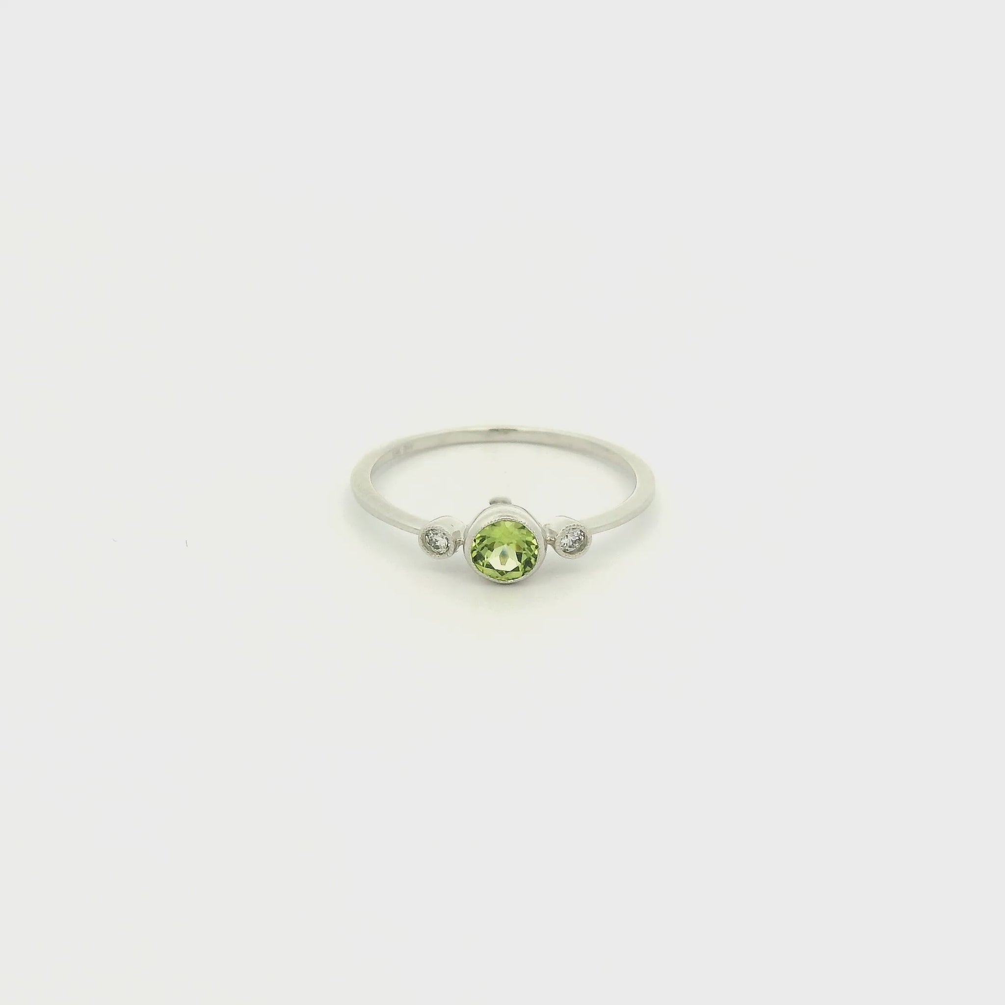 A White Gold Ring with a milgrain bezel set round cut natural Peridot in the center with 2 bezel set Natural Diamonds at Forever Rox Fine Jewelry, Lake Tahoes Best Jewelry Store
