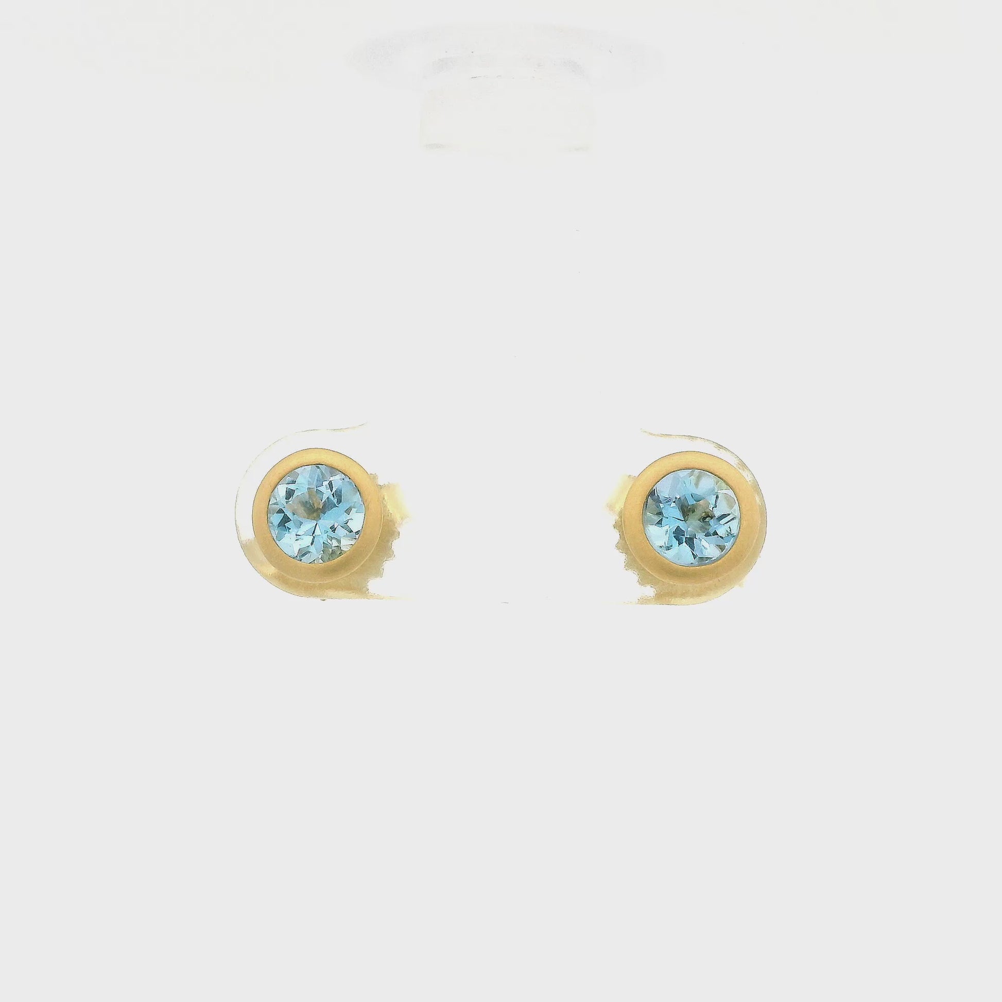 A Pair of Yellow Gold Stud Earrings with bezel set round cut Aquamarines in the center at Lake Tahoes best Jewelry Store, Forever Rox Fine Jewelry