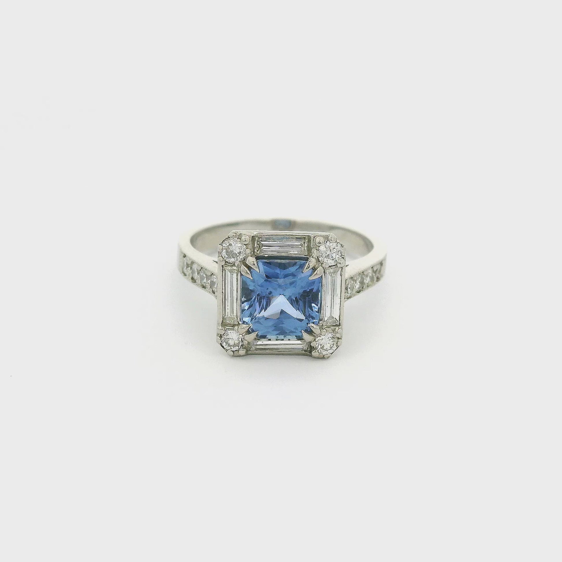 A Platinum Ring with a prong set square cushion cut blue Ceylonese Sapphire in the center with four baguette and four round cut diamonds around it with four round cut diamonds down each side of the shank at Forever Rox Fine Jewelry, Lake Tahoes Best Jewelry Store