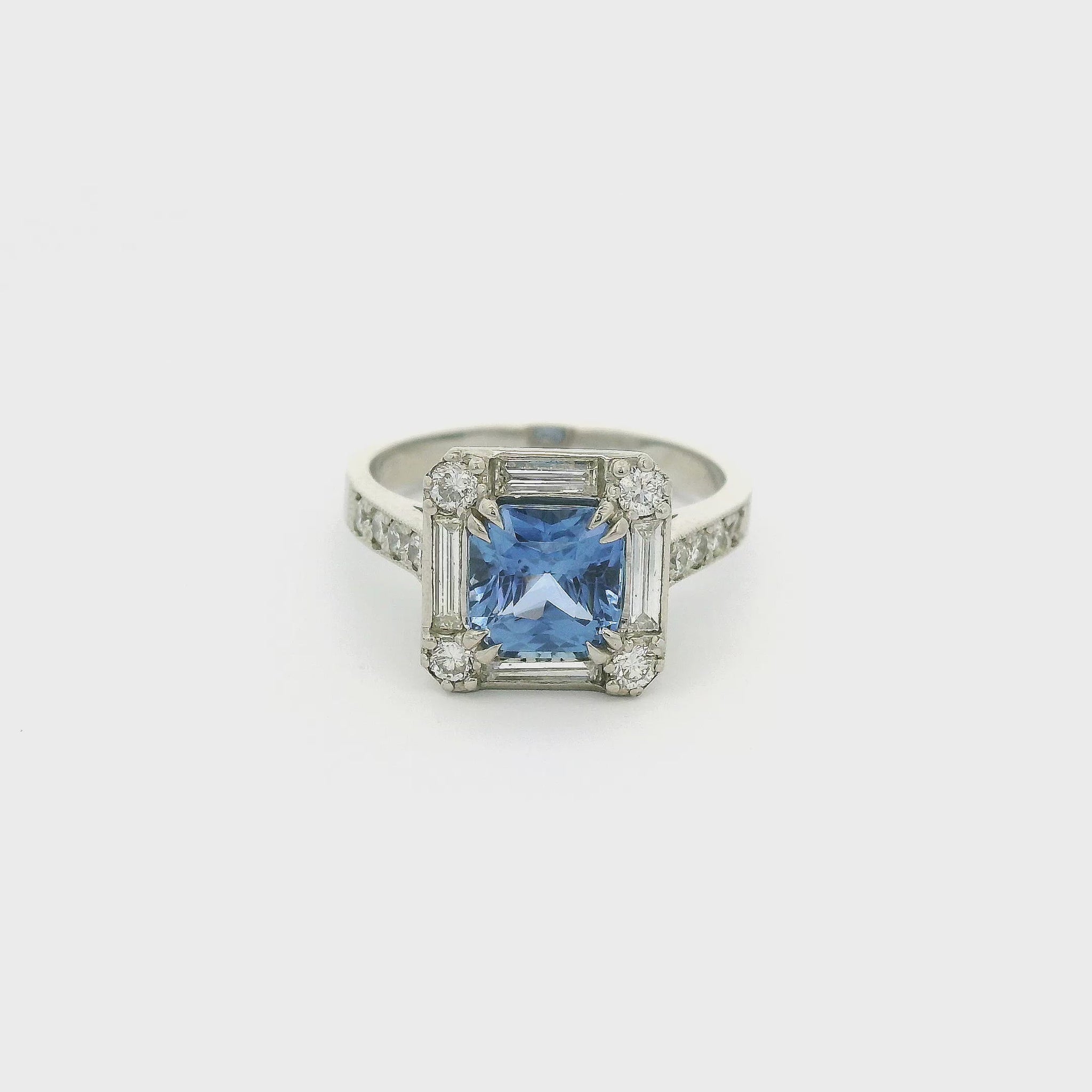 A Platinum Ring with a prong set square cushion cut blue Ceylonese Sapphire in the center with four baguette and four round cut diamonds around it with four round cut diamonds down each side of the shank at Forever Rox Fine Jewelry, Lake Tahoes Best Jewelry Store