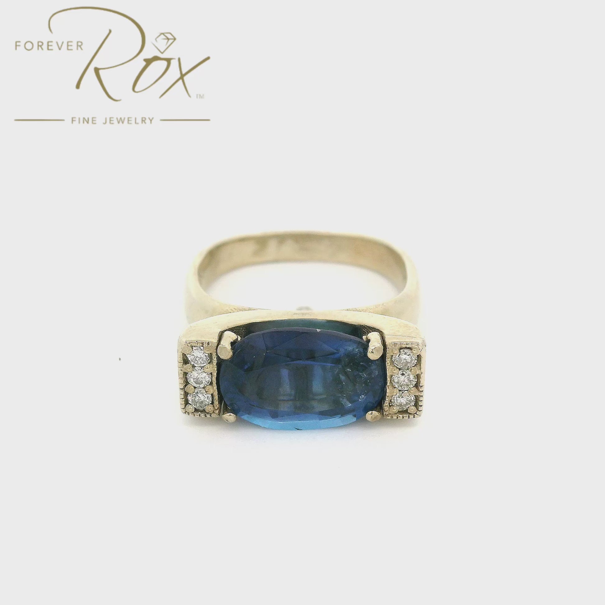 A White Gold Ring with a prong set oval cut natural Tanzanite in the center with three diamonds on either end at Forever Rox Fine Jewelry, Lake Tahoes Best Jewelry Store