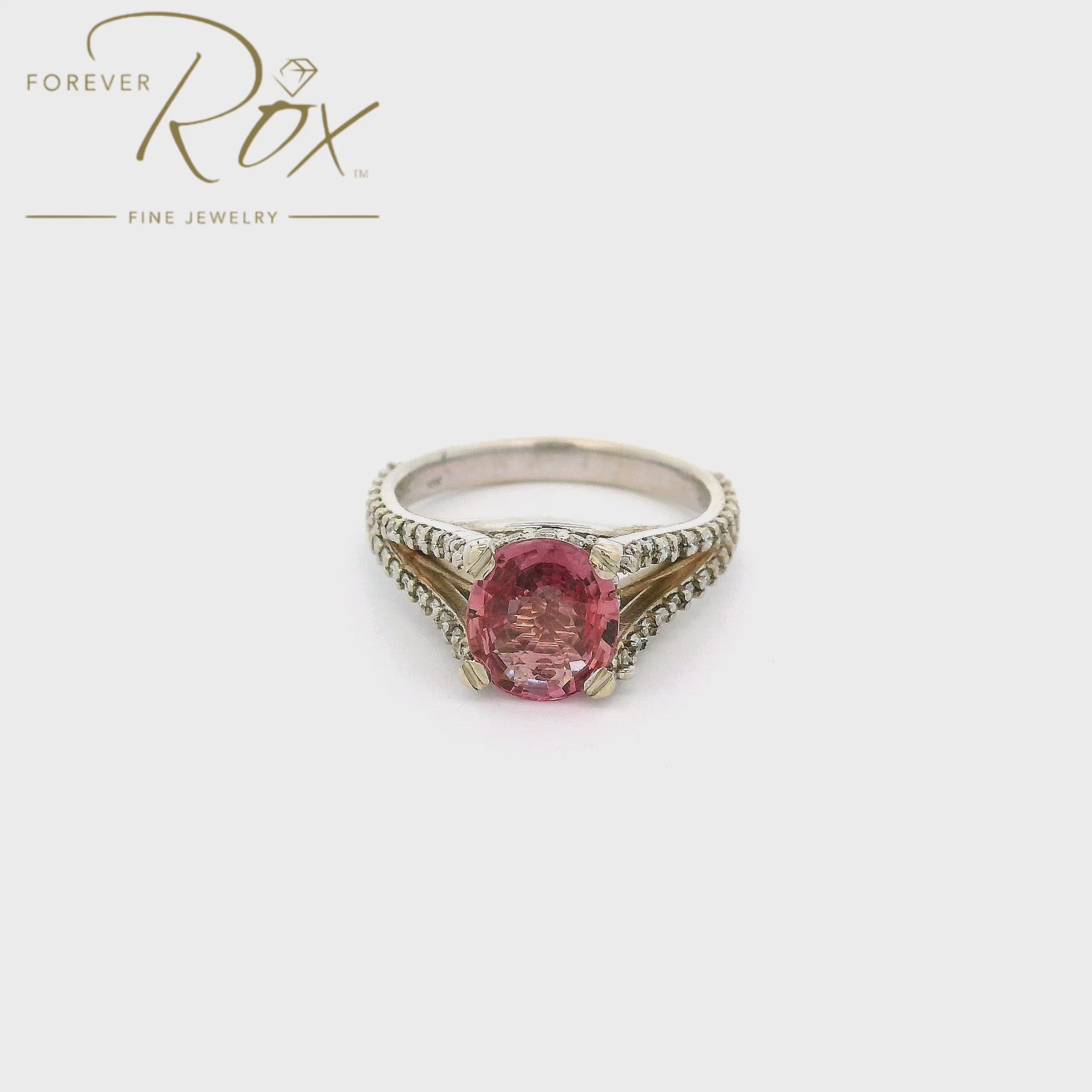 A White Gold Ring with a prong set oval cut natural AGL Certified Padparadscha Sapphire in the center wdiamond accents on the ring at Forever Rox Fine Jewelry, Lake Tahoes Best Jewelry Store

