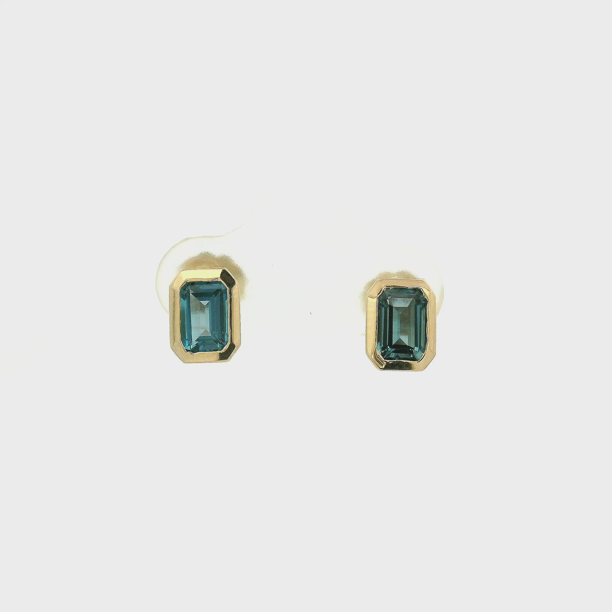 A Pair of Yellow Gold Stud Earrings with bezel set emerald cut natural London BLue Topaz at Forever Rox Fine Jewelry, Lake Tahoes Best Jewelry Store
