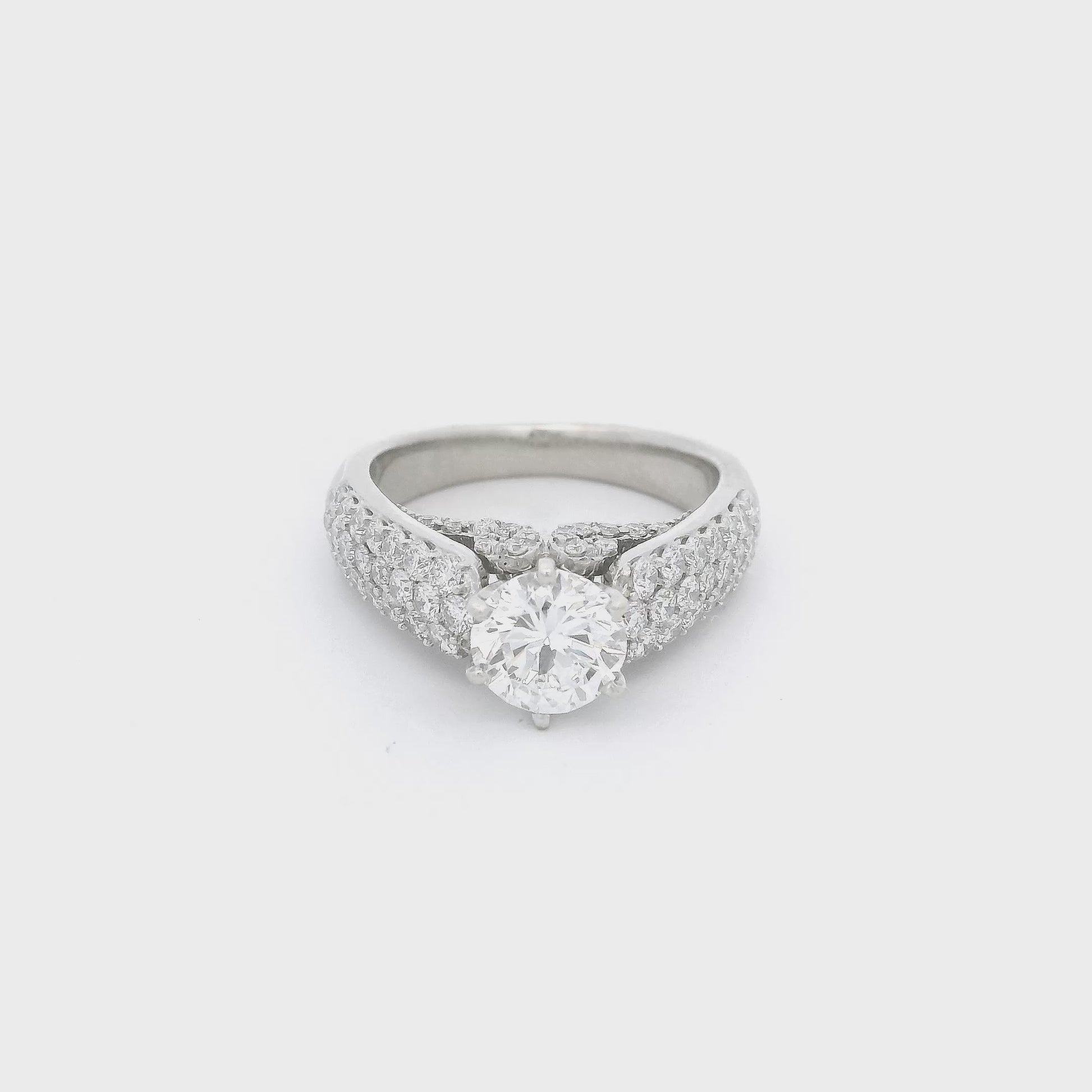 White Gold ring with a round cut diamond in the center, pavé set diamonds down the side of the shank and diamond desing on the face of the ring below the center diamond at Forever Rox Fine Jewelry