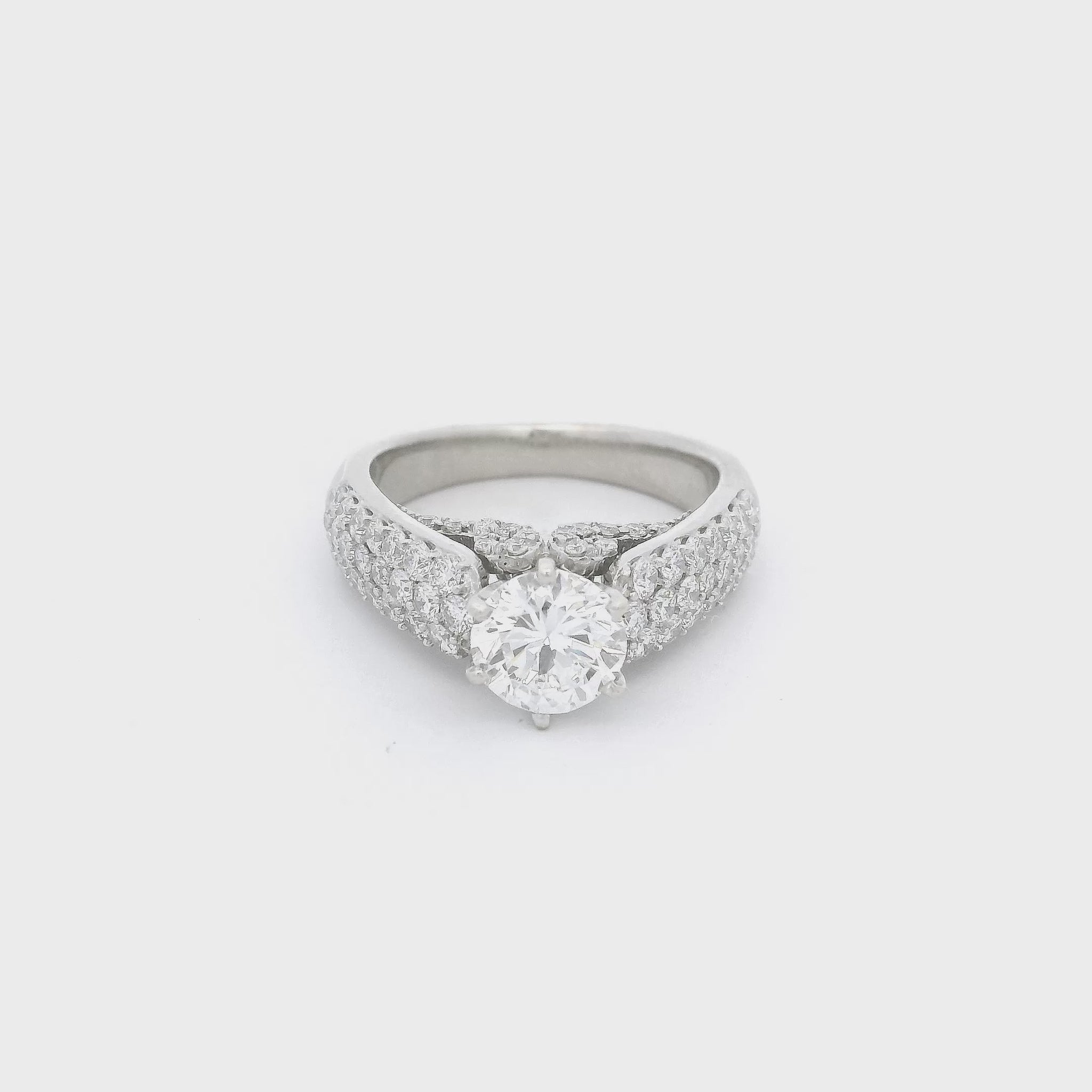 White Gold ring with a round cut diamond in the center, pavé set diamonds down the side of the shank and diamond desing on the face of the ring below the center diamond at Forever Rox Fine Jewelry