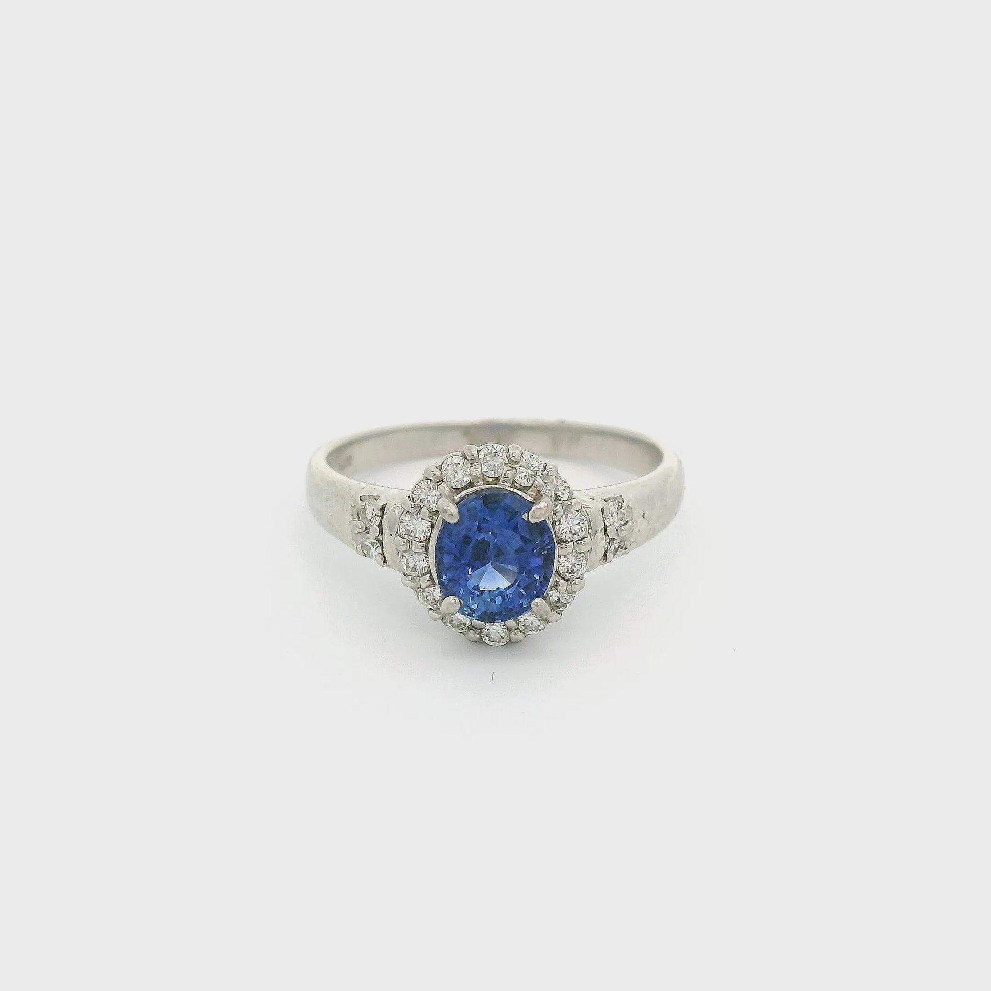 Platinum Ring with one oval cut sapphire in the center and a diamond halo with diamond accents on the band at Forever Rox Fine Jewelry