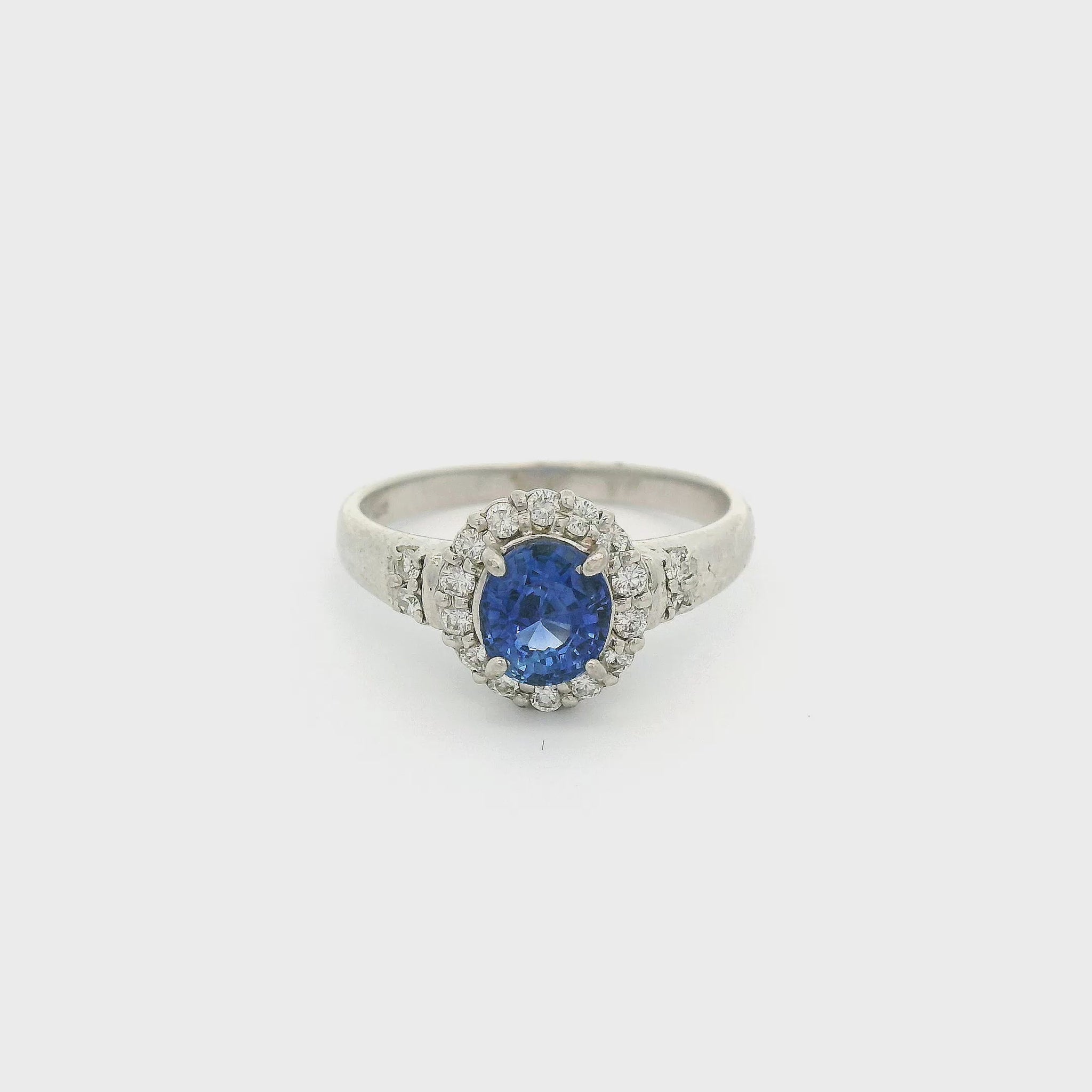 Platinum Ring with one oval cut sapphire in the center and a diamond halo with diamond accents on the band at Forever Rox Fine Jewelry