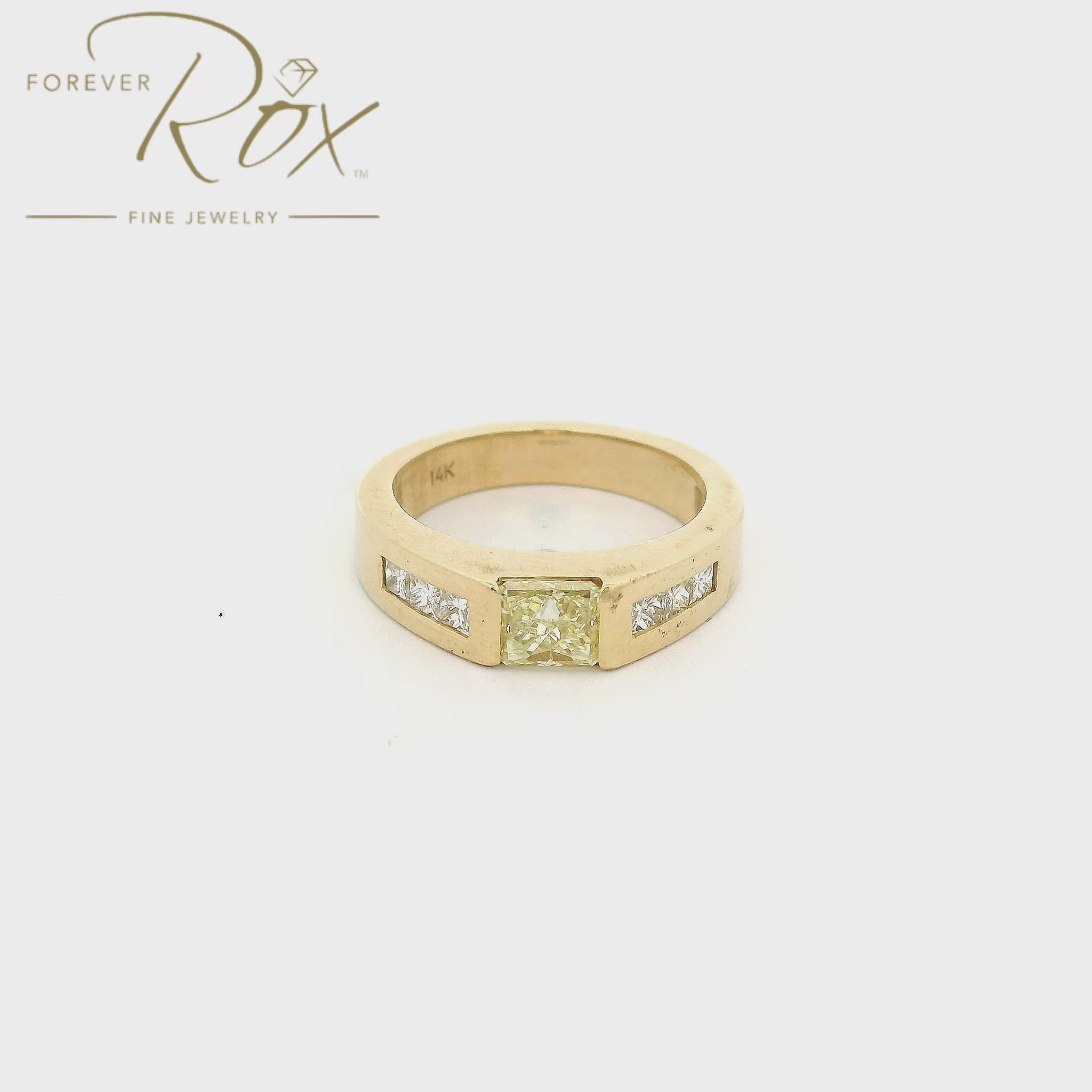 Yellow Gold bridal ring with a single fancy yellow princess cut diamond in the center and 3 white princess cut diamonds channel set down each side of the ring at Forever Rox Fine Jewelry