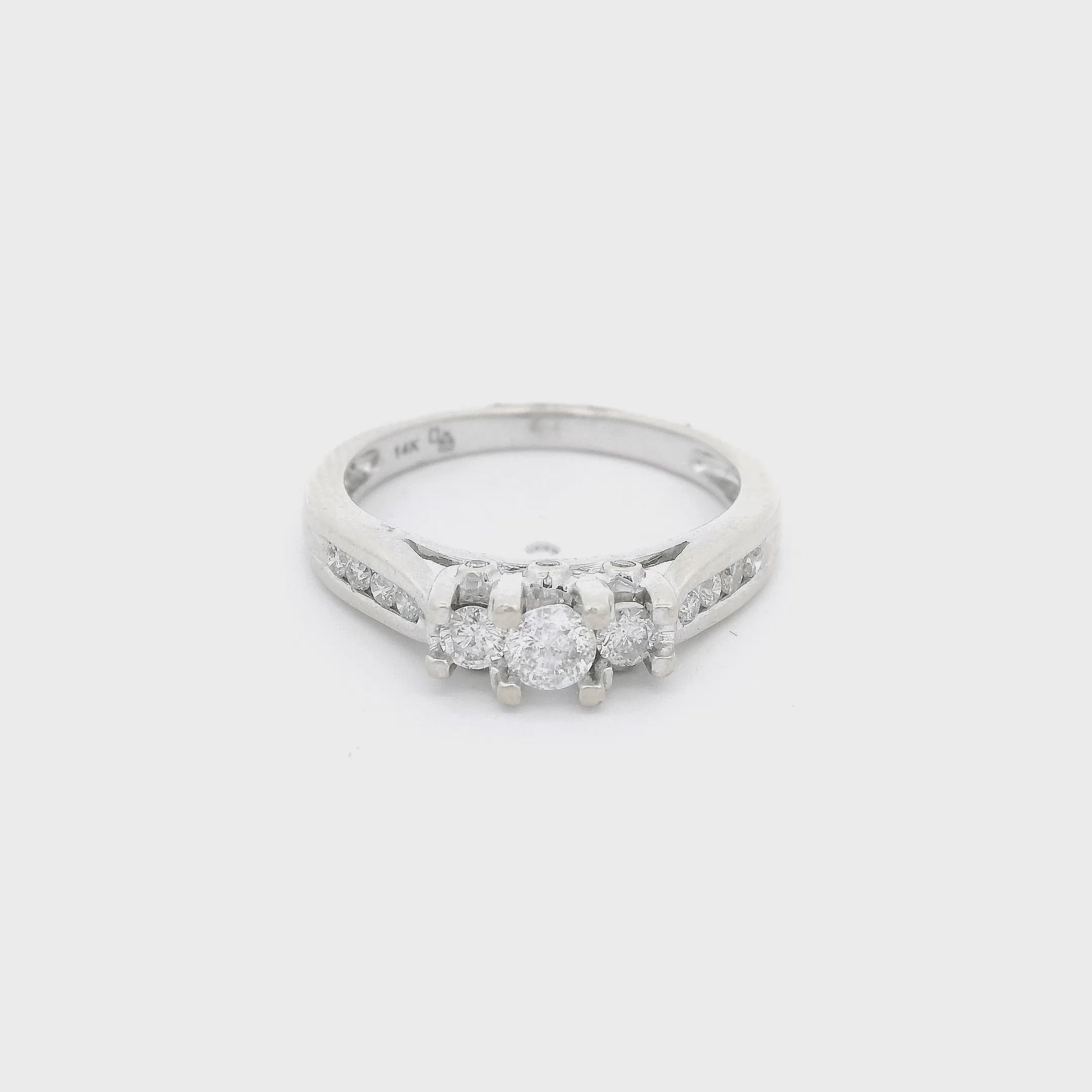 White Gold ring with three diamonds set in center with the center one bigger than the other two and four diamonds channel set down each side of the shank at Forever Rox Fine Jewelry