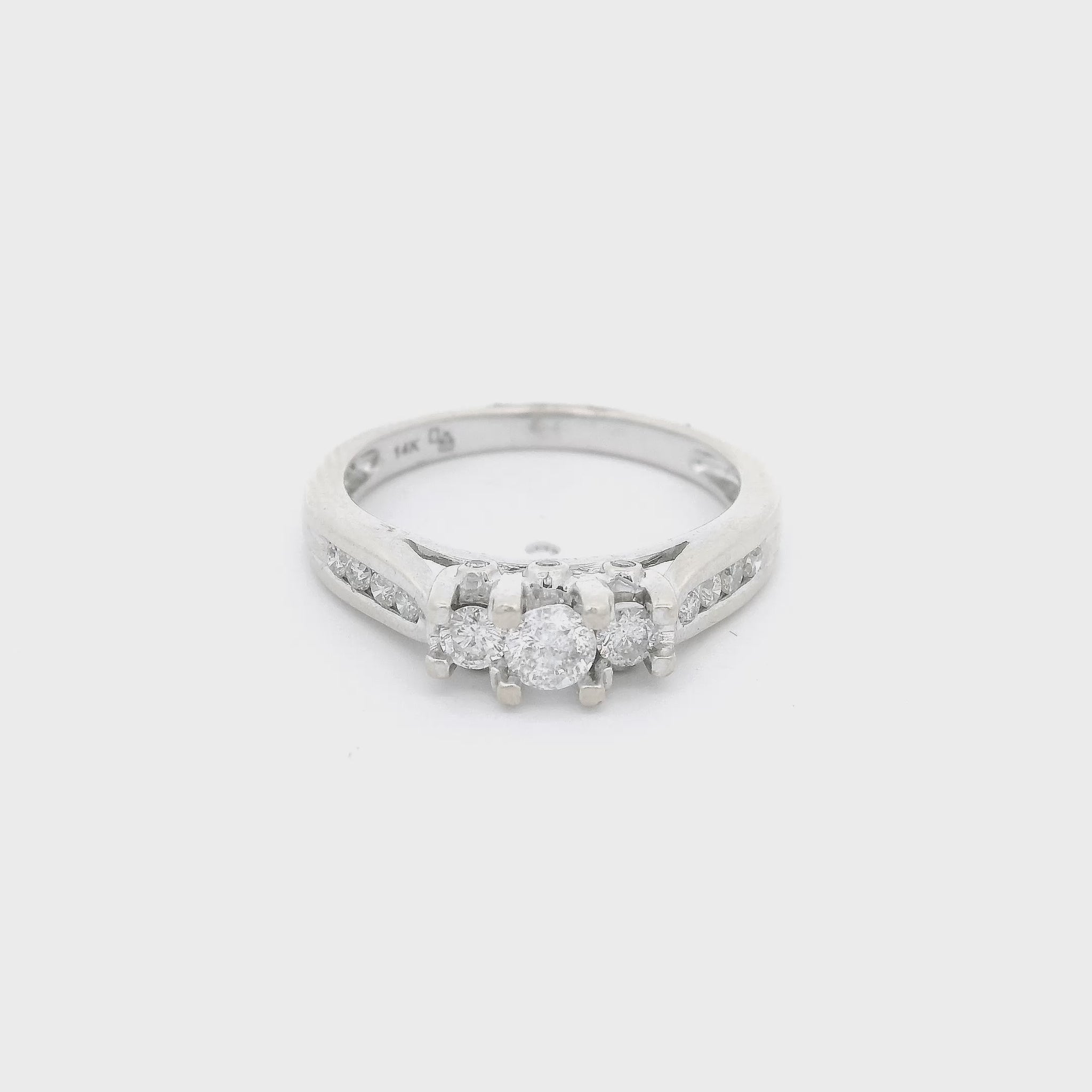 White Gold ring with three diamonds set in center with the center one bigger than the other two and four diamonds channel set down each side of the shank at Forever Rox Fine Jewelry