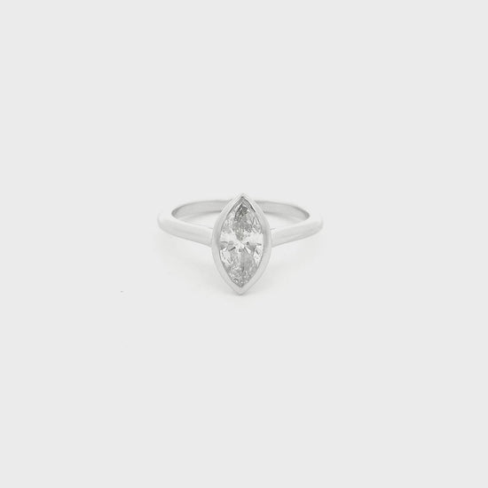 This custom ring showcases a stunning 1.04 carat natural marquise cut diamond elegantly bezel set in platinum. Designed with clean lines and a delicate, flowing band, the minimalist setting allows the diamond’s graceful silhouette to take center stage while offering exceptional security and everyday wearability. A timeless custom design that perfectly balances modern simplicity with the enduring beauty of a natural diamond.