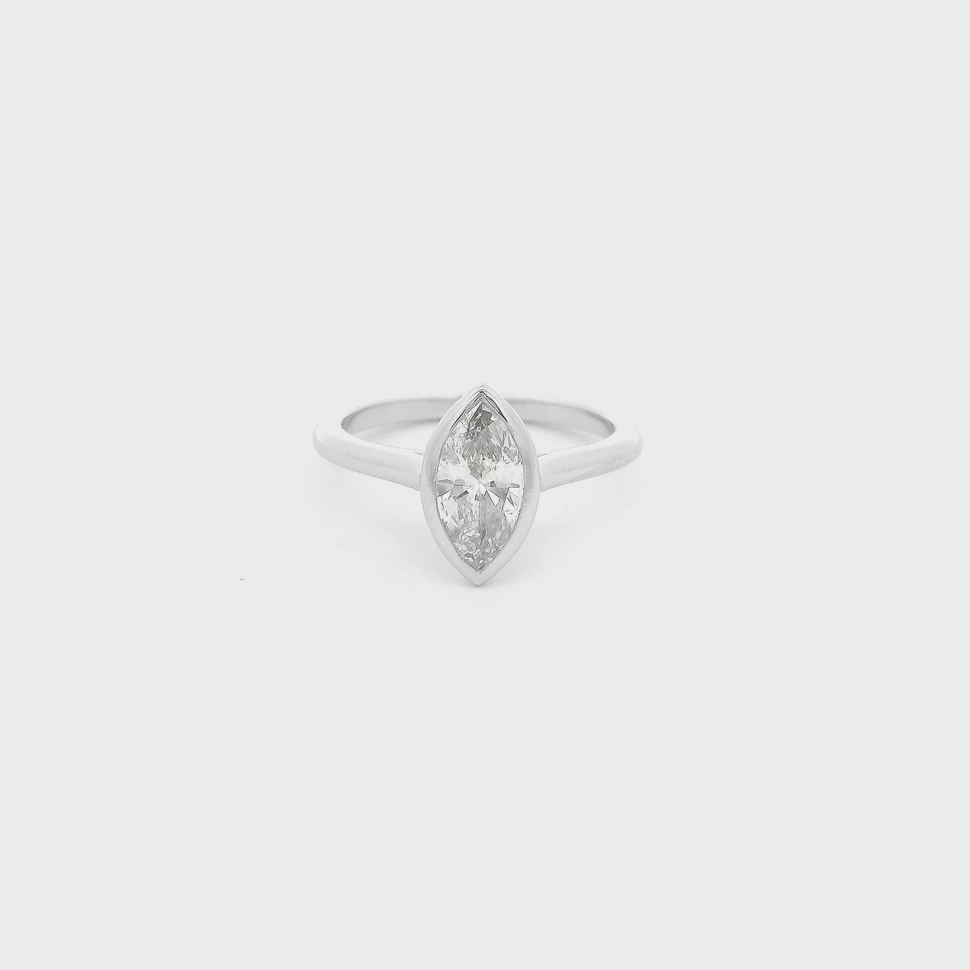 This custom ring showcases a stunning 1.04 carat natural marquise cut diamond elegantly bezel set in platinum. Designed with clean lines and a delicate, flowing band, the minimalist setting allows the diamond’s graceful silhouette to take center stage while offering exceptional security and everyday wearability. A timeless custom design that perfectly balances modern simplicity with the enduring beauty of a natural diamond.