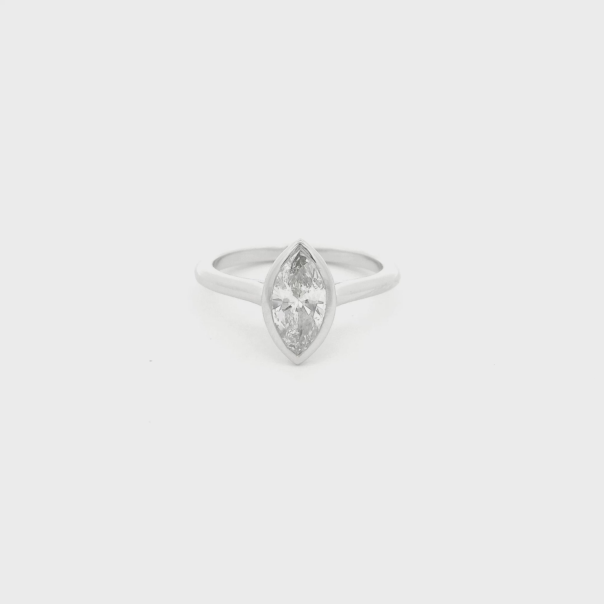 This custom ring showcases a stunning 1.04 carat natural marquise cut diamond elegantly bezel set in platinum. Designed with clean lines and a delicate, flowing band, the minimalist setting allows the diamond’s graceful silhouette to take center stage while offering exceptional security and everyday wearability. A timeless custom design that perfectly balances modern simplicity with the enduring beauty of a natural diamond.