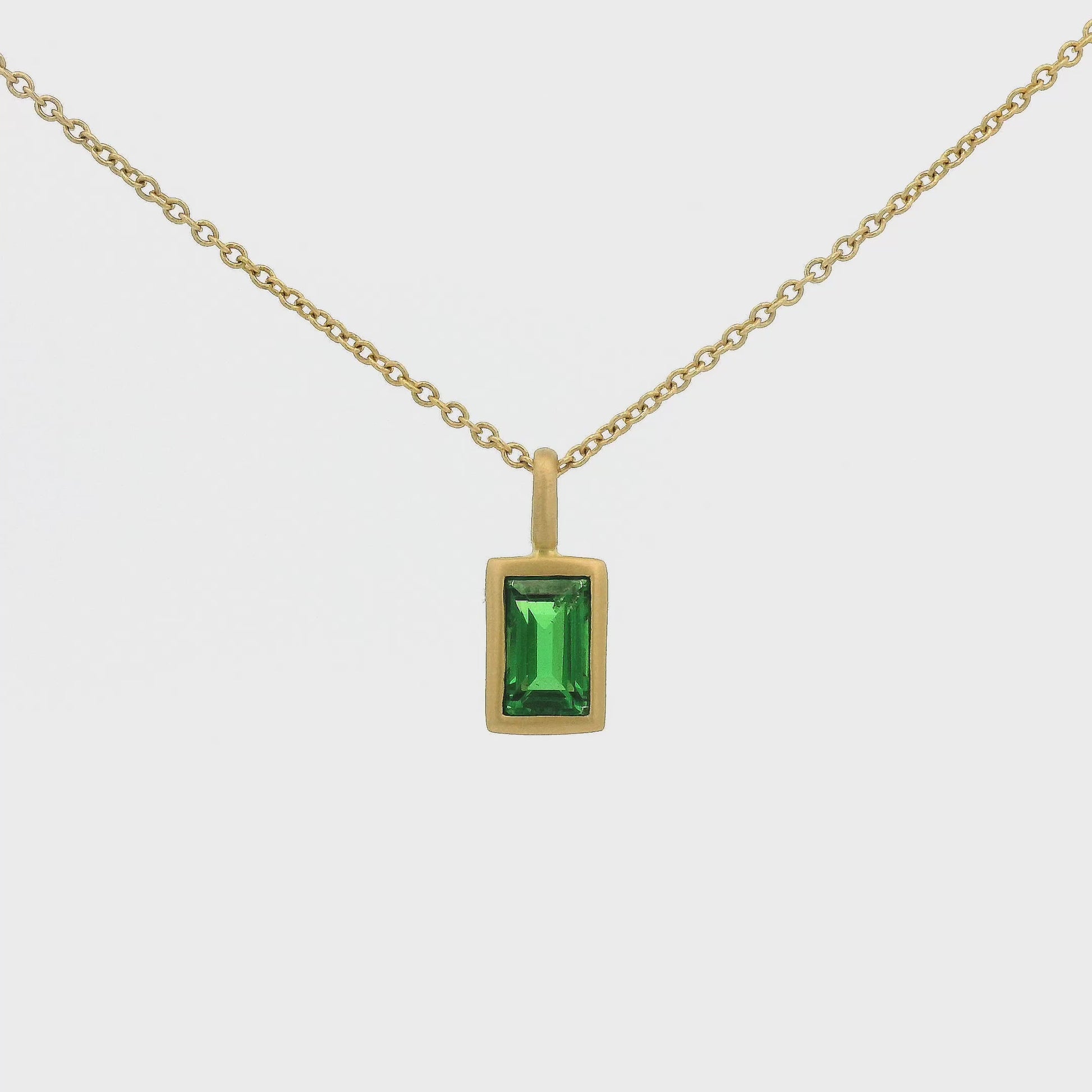 A Yellow Gold Pendant with a solitaire bezel set emerald cut Tsavorite Garnet Forever Rox Fine Jewelry, Lake Tahoes Best Jewelry Store