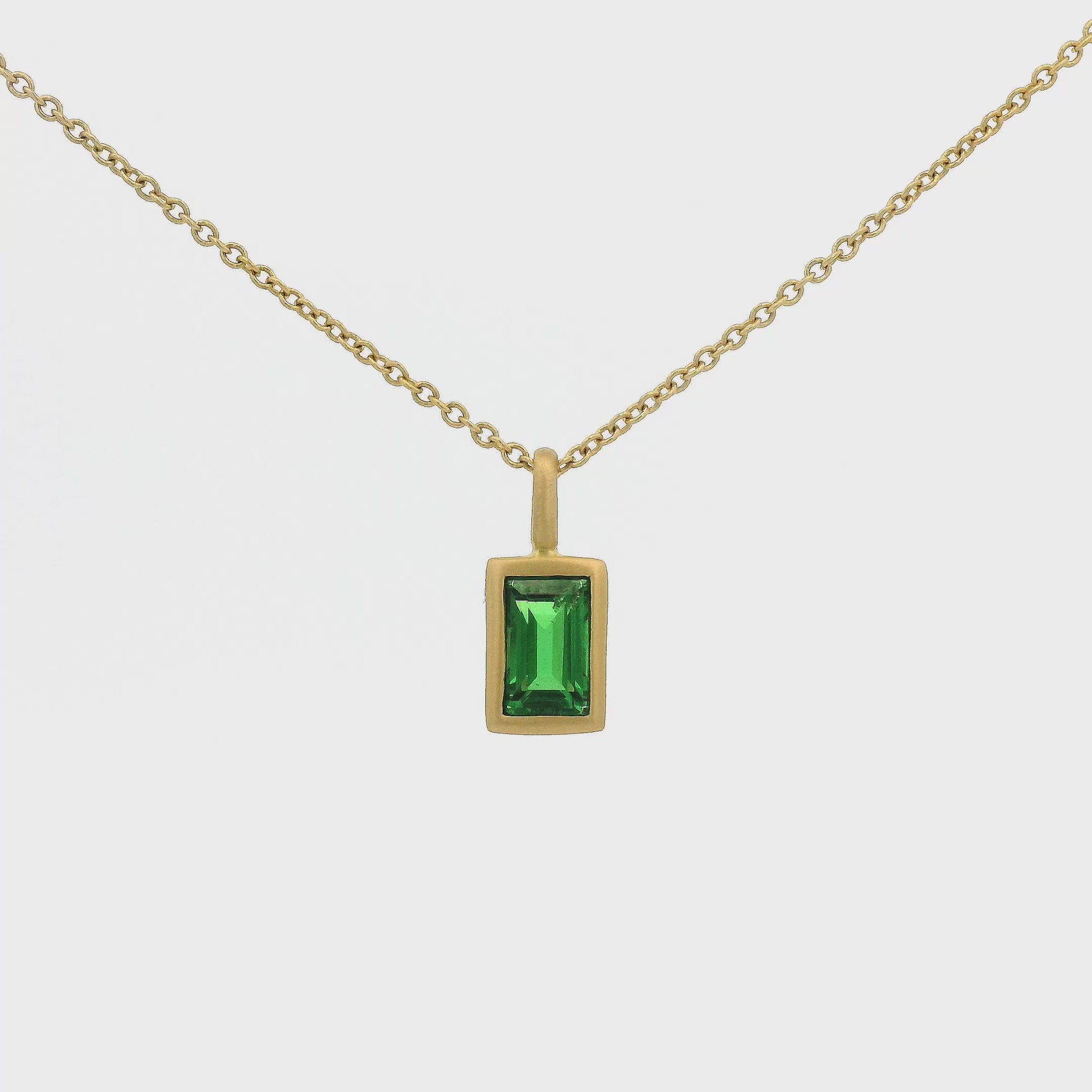 A Yellow Gold Pendant with a solitaire bezel set emerald cut Tsavorite Garnet Forever Rox Fine Jewelry, Lake Tahoes Best Jewelry Store