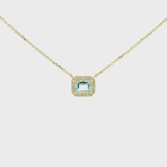 A Yellow Gold Pendant with a prong set emerald cut natural Aquamarine in the center with a diamond halo at Forever Rox Fine Jewelry, Lake Tahoes Best Jewelry Store