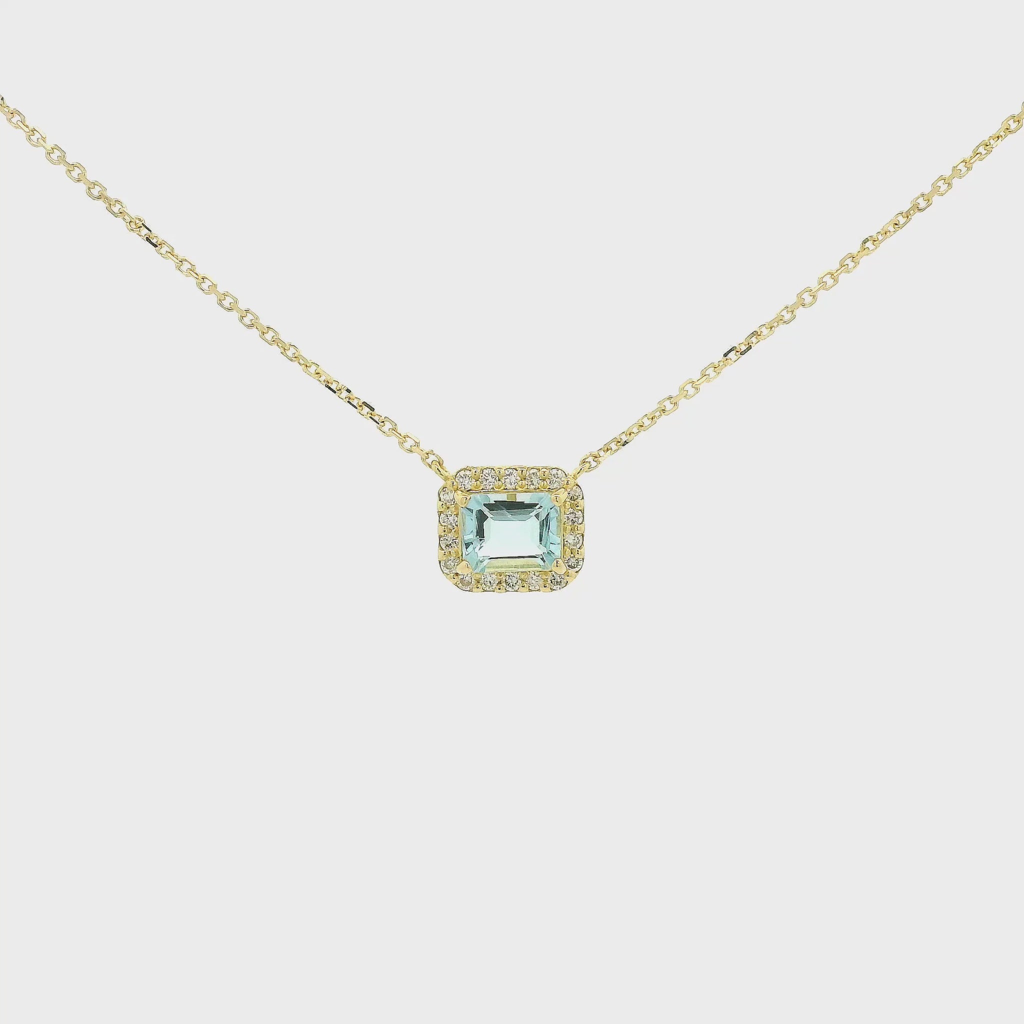 A Yellow Gold Pendant with a prong set emerald cut natural Aquamarine in the center with a diamond halo at Forever Rox Fine Jewelry, Lake Tahoes Best Jewelry Store