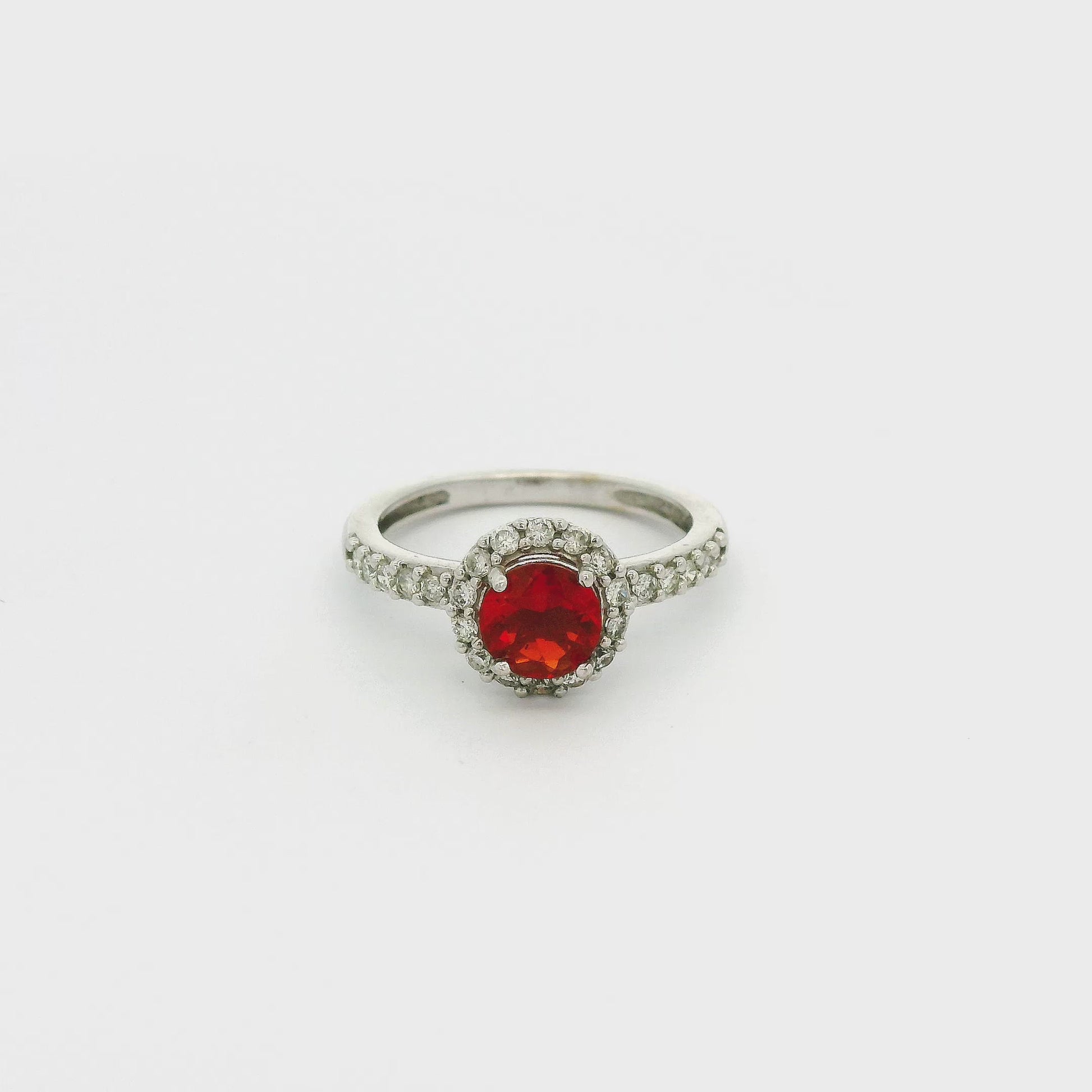 A White Gold Ring with a prong set round cut Fire Opal in the center with a halo of diamonds and diamonds down the shank at Forever Rox Fine Jewelry, Lake Tahoes Best Jewelry Store