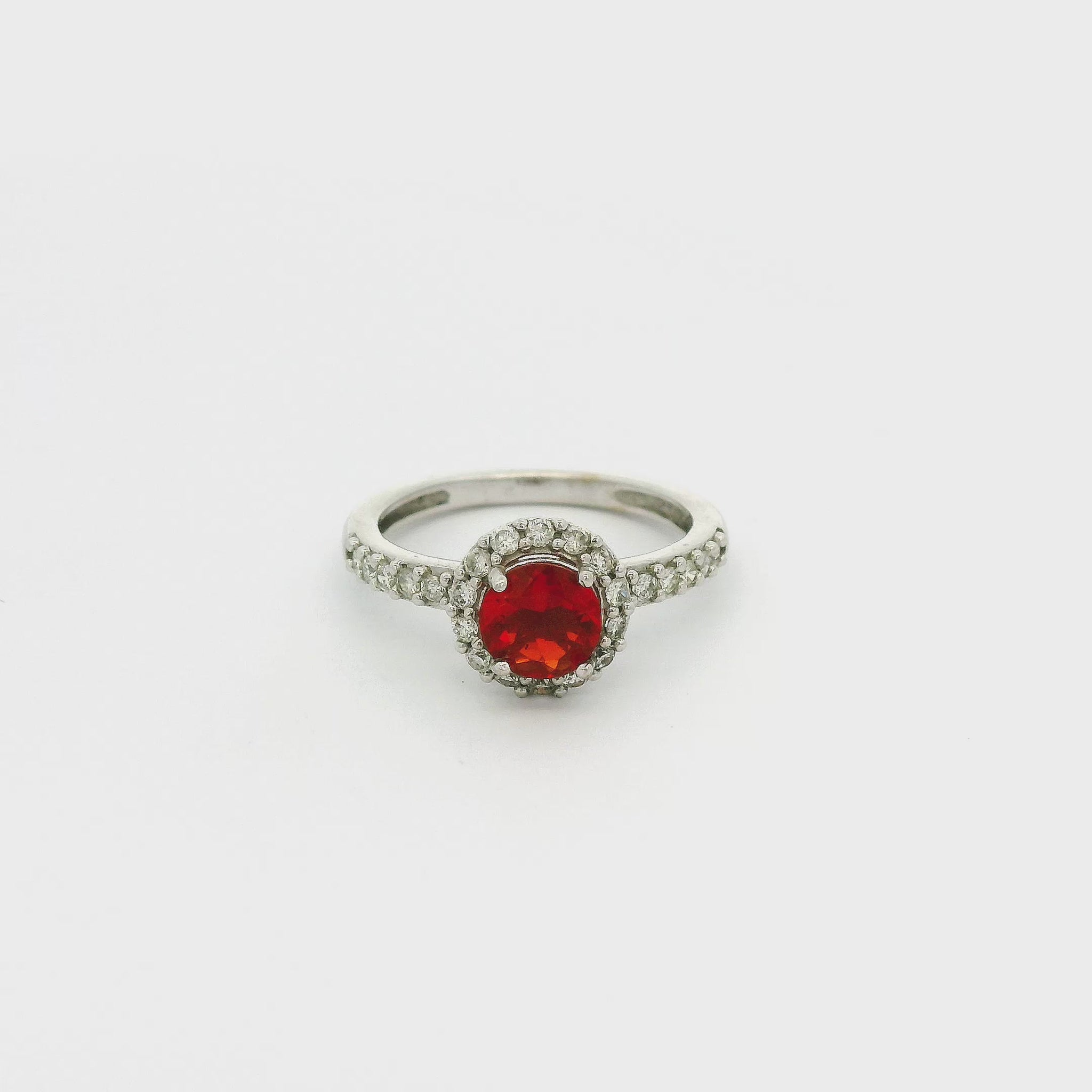 A White Gold Ring with a prong set round cut Fire Opal in the center with a halo of diamonds and diamonds down the shank at Forever Rox Fine Jewelry, Lake Tahoes Best Jewelry Store