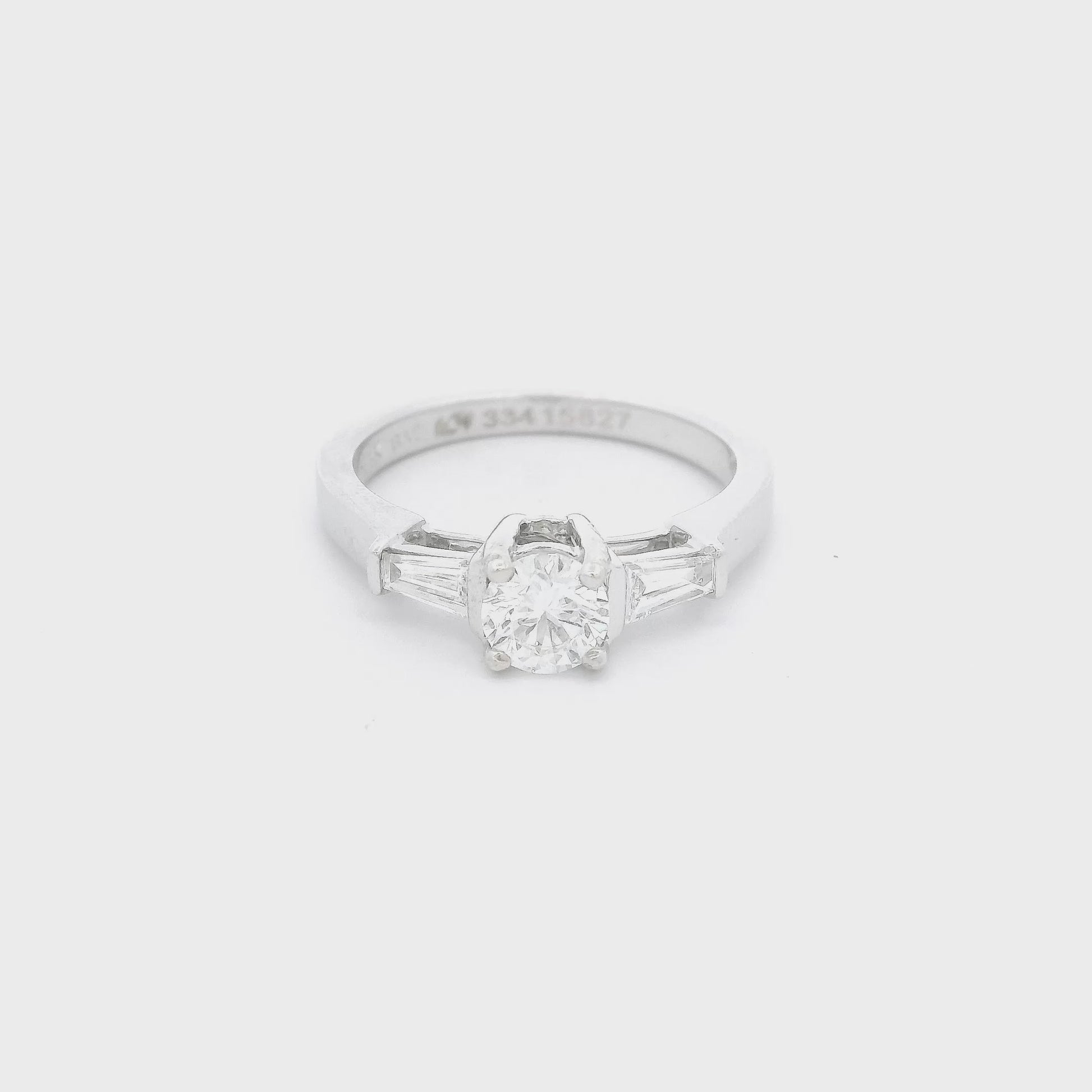 White Gold ring with a round cut diamond in the center and one tapered baguette diamond on each side of the center Diamond at Forever Rox Fine Jewelry