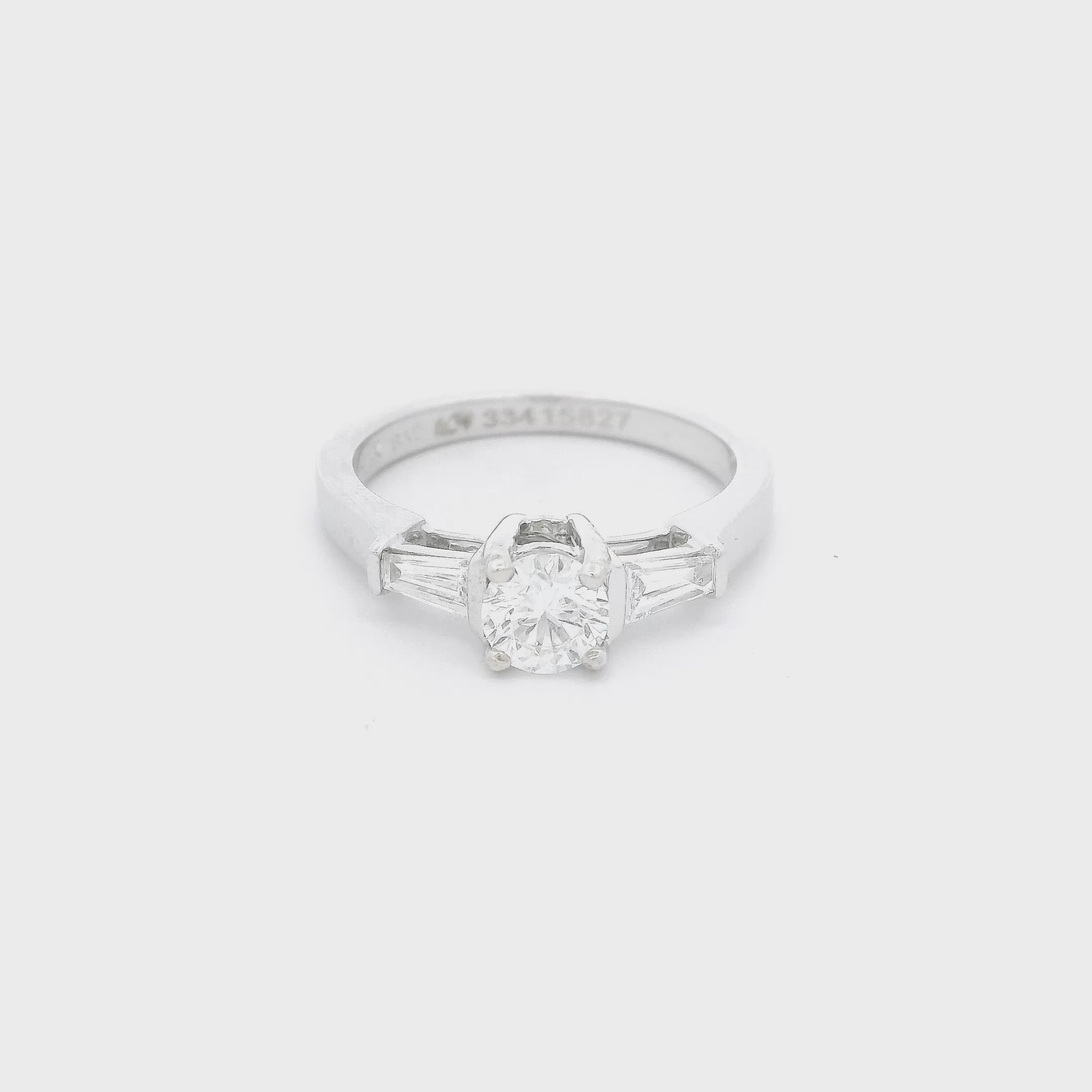 White Gold ring with a round cut diamond in the center and one tapered baguette diamond on each side of the center Diamond at Forever Rox Fine Jewelry