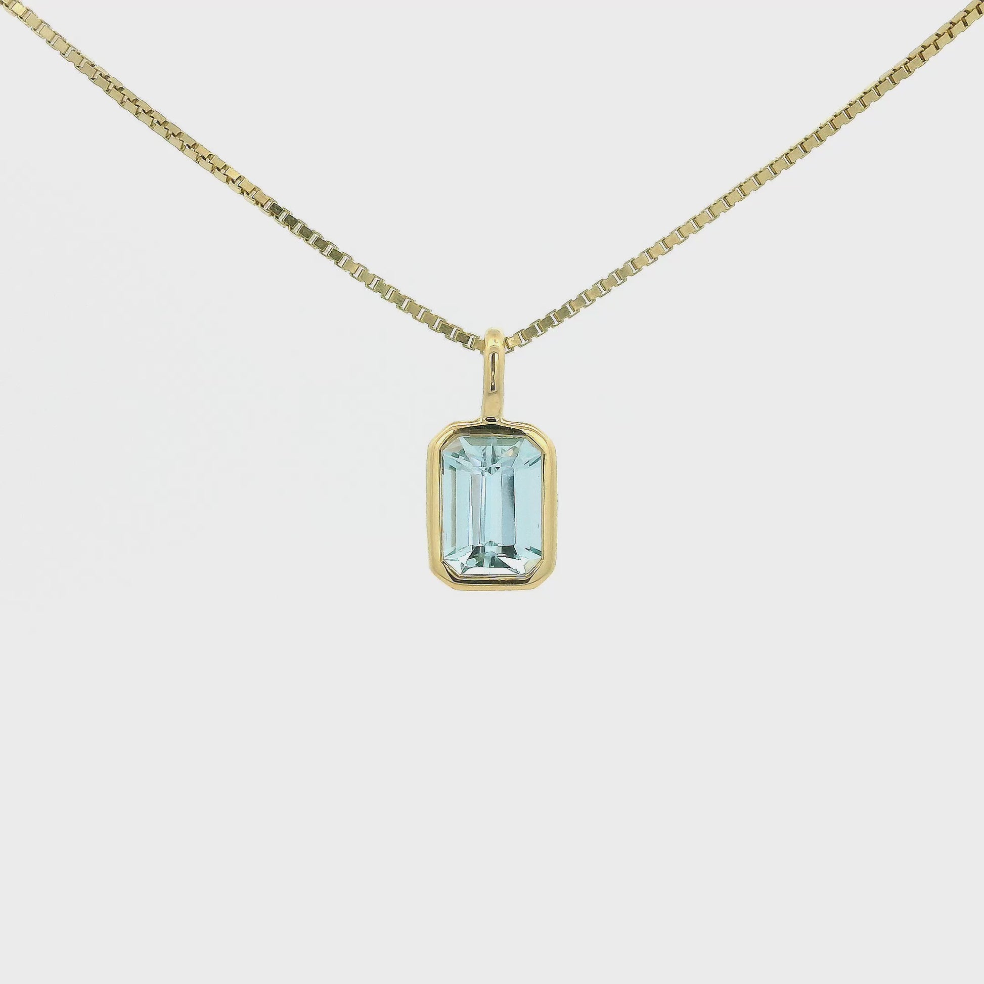 A Yellow Gold Pendant with a bezel set emerald cut natural Aquamarine in the center at Forever Rox Fine Jewelry, Lake Tahoes Best Jewelry Store