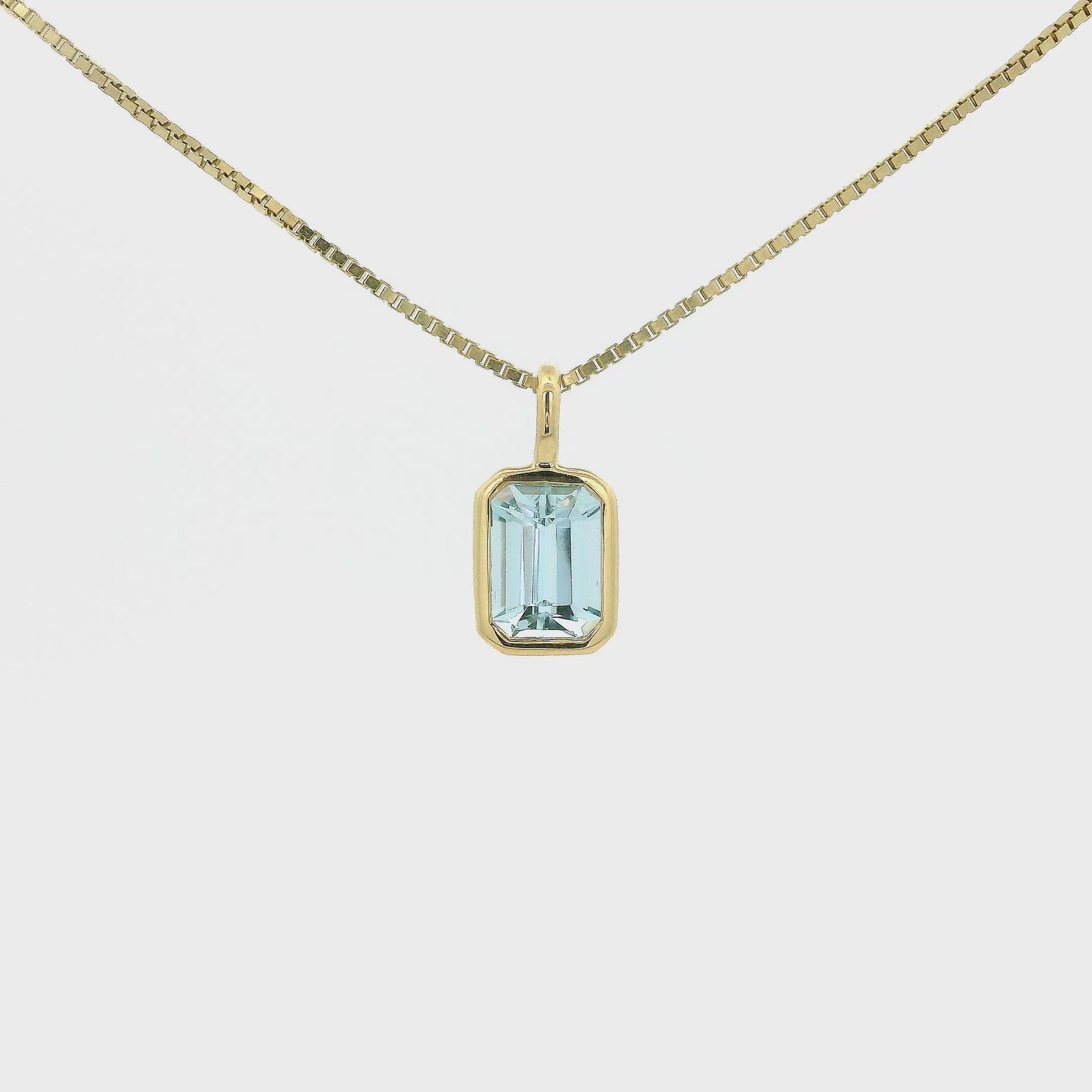 A Yellow Gold Pendant with a bezel set emerald cut natural Aquamarine in the center at Forever Rox Fine Jewelry, Lake Tahoes Best Jewelry Store