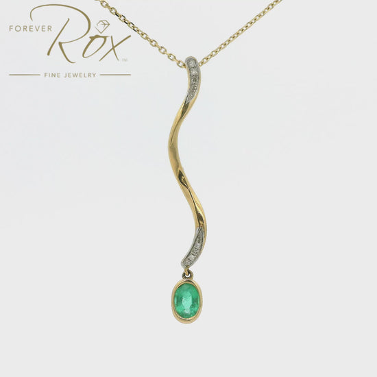A Yellow Gold Pendant with a bezel set oval cut Emerald dangling at the bottom of a snake design pendant with diamonds at Forever Rox Fine Jewelry, Lake Tahoes Best Jewelry Store