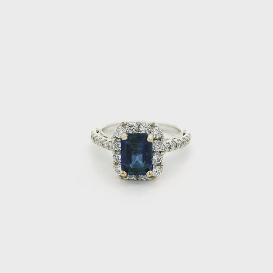 A White Gold Ring with a prong set emerald cut natural Sapphire in the center with a halo of diamonds and diamonds down the shank at Forever Rox Fine Jewelry, Lake Tahoes Best Jewelry Store
