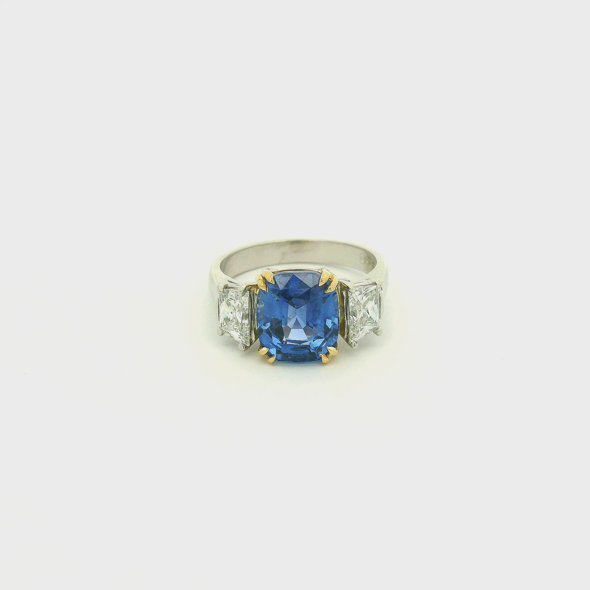 A Platinum & Yellow Gold Ring with a prong set natural TGC Certified No Heat Cushion Cut Cornflower Blue Sapphire & 2 Trapazoid Cut Diamonds at Forever Rox Fine Jewelry, Lake Tahoes Best Jewelry Store