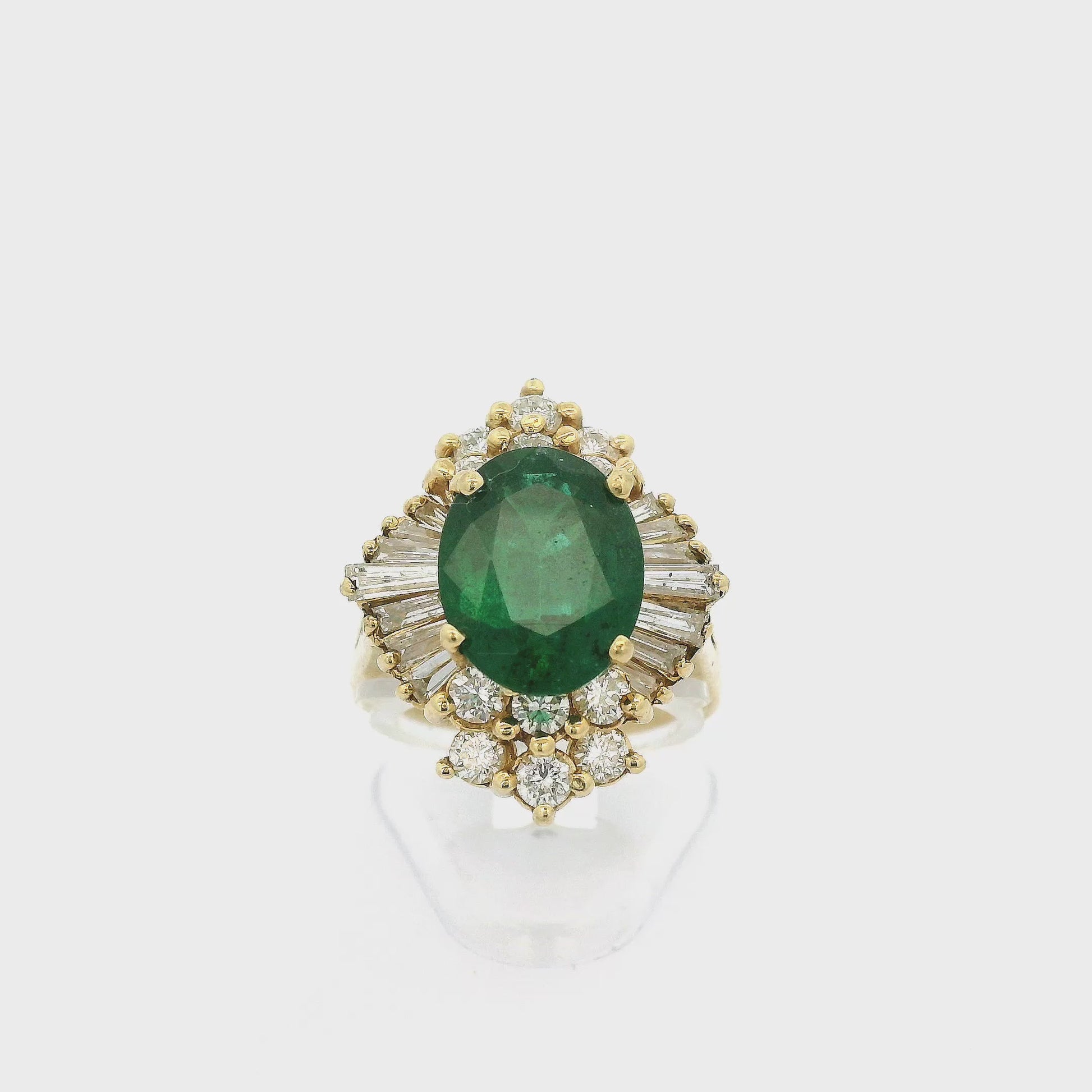 A Yellow Gold Ring with a prong set oval cut Emerald in the center and with baguette & round cut Diamonds around it at Forever Rox Fine Jewelry, Lake Tahoes Best Jewelry Store