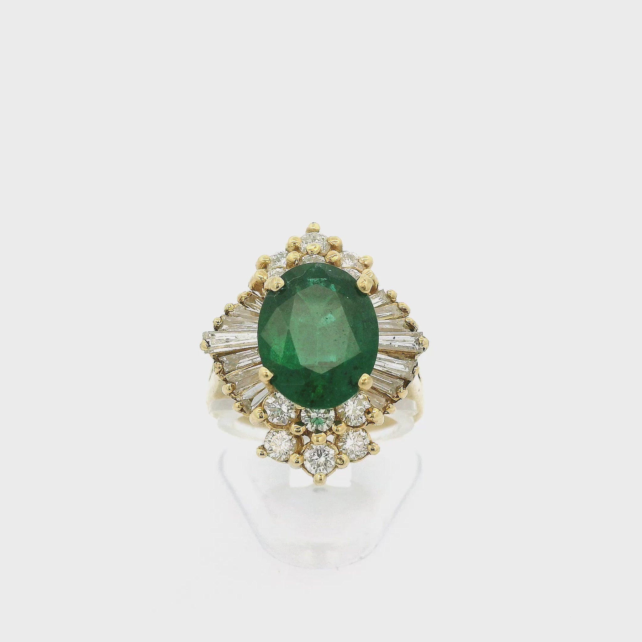A Yellow Gold Ring with a prong set oval cut Emerald in the center and with baguette & round cut Diamonds around it at Forever Rox Fine Jewelry, Lake Tahoes Best Jewelry Store