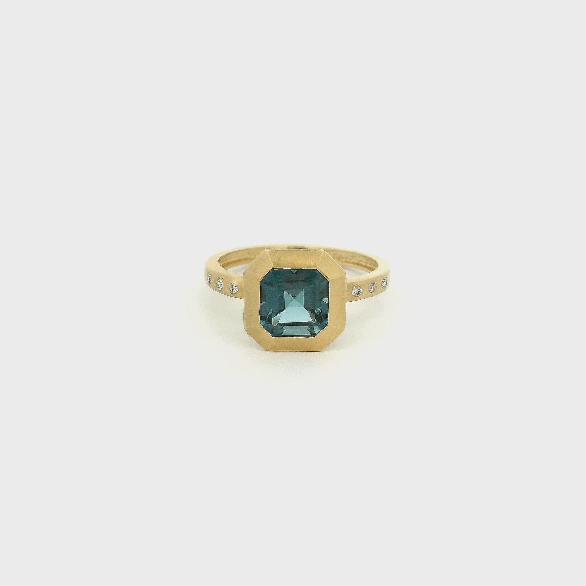 A Yellow Gold Ring with a bezel set square merald cut cut natural London Blue Topaz in the center with flush set diamonds in the band at Forever Rox Fine Jewelry, Lake Tahoes Best Jewelry Store
