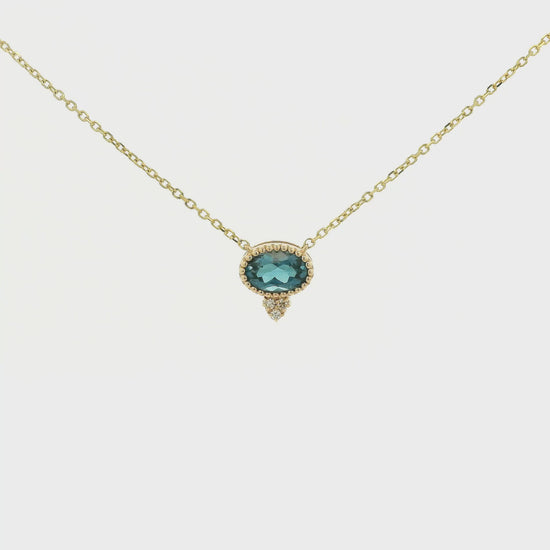 A Yellow Gold Pendant with a milgrain bezel set oval cut natural London Blue Topaz in the center with 3 diamonds and a chain attached at Forever Rox Fine Jewelry, Lake Tahoes Best Jewelry Store