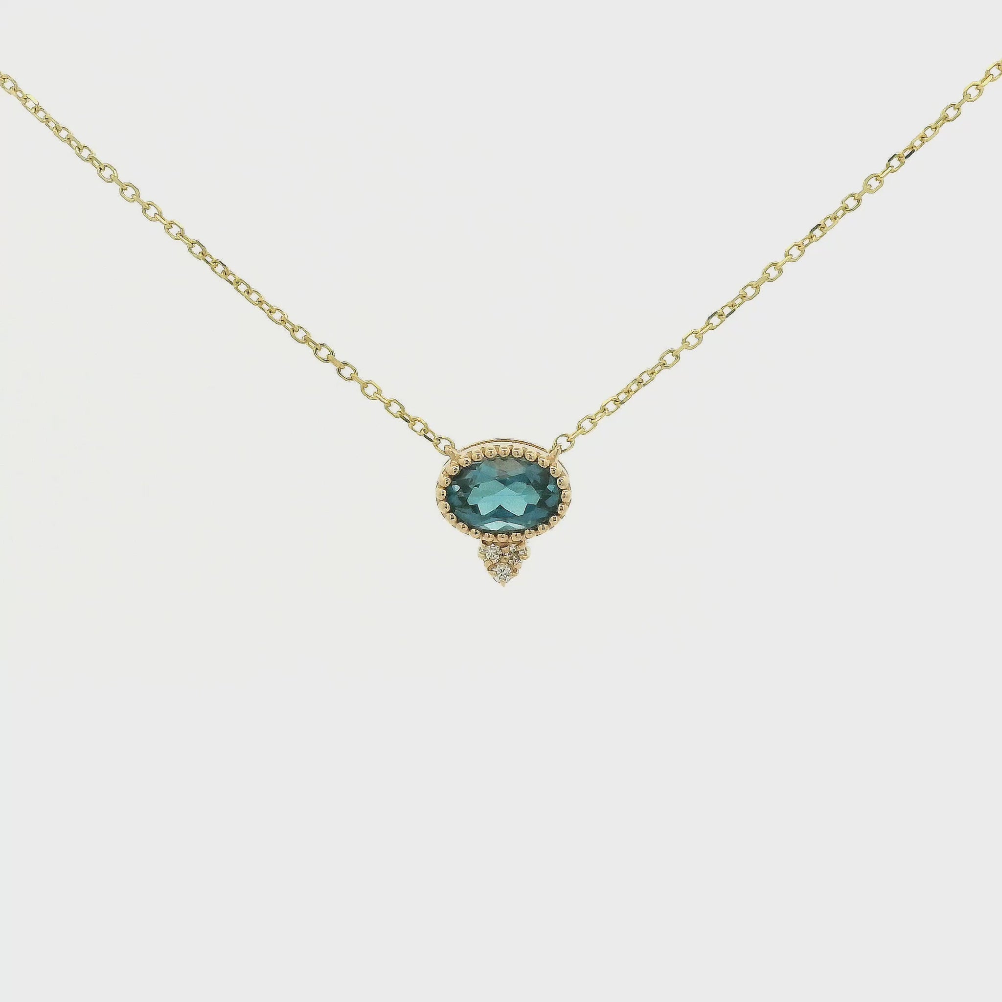 A Yellow Gold Pendant with a milgrain bezel set oval cut natural London Blue Topaz in the center with 3 diamonds and a chain attached at Forever Rox Fine Jewelry, Lake Tahoes Best Jewelry Store