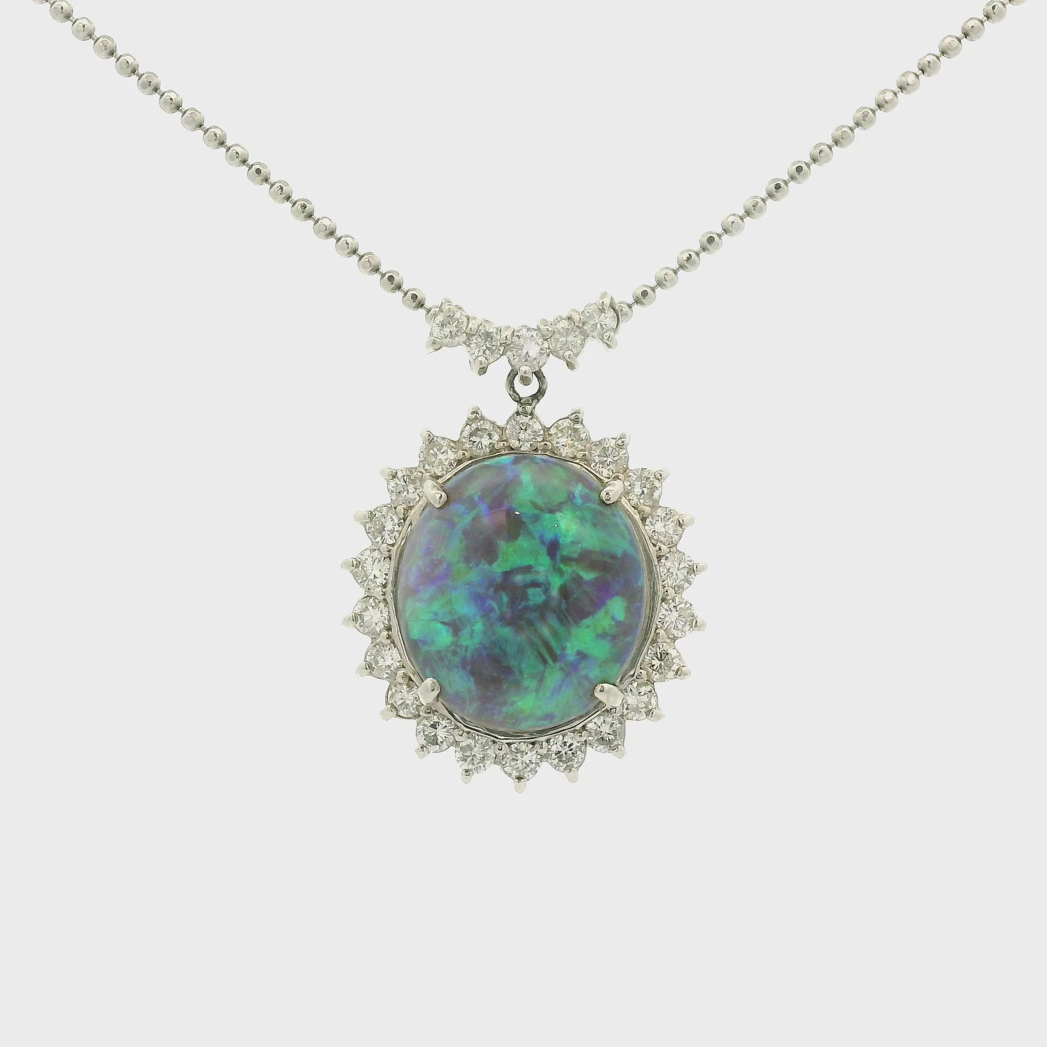 A Platinum Pendant with a prong set round cut natural Black Lightning Ridge Opal in the center with a halo of diamonds around it at Forever Rox Fine Jewelry, Lake Tahoes Best Jewelry Store
