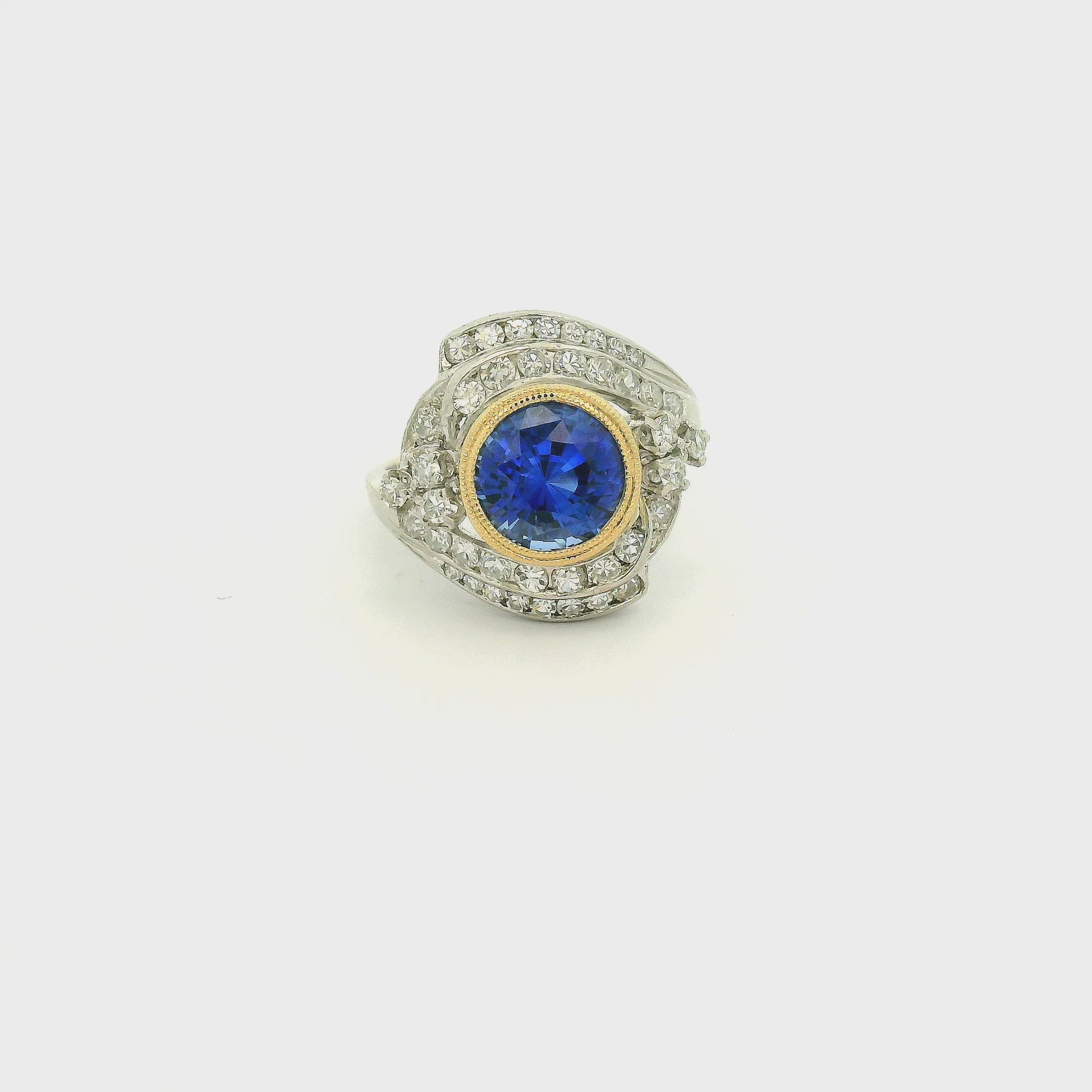 A Vintage Platinum & Yellow Gold Ring with a milgrain bezel set round cut natural Fine Blue Sapphire in the center with diamonds scattered around at Forever Rox Fine Jewelry, Lake Tahoes Best Jewelry Store
