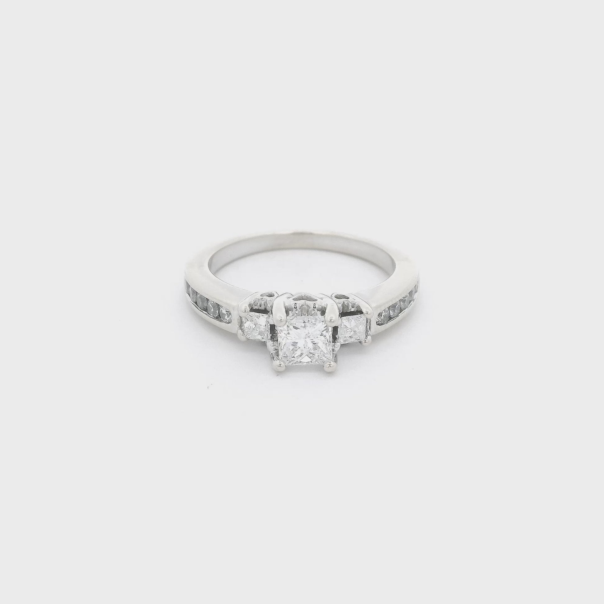 White Gold ring with three princess cut diamonds in the center and four round cut diamonds channel set down each side of the shank and 2 diamonds inside the shank at Forever Rox Fine Jewelry