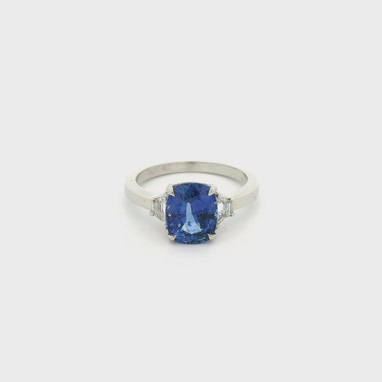 A White Gold Ring with a prong set cushion cut natural Sapphire in the center with two trillion cut Diamonds at Forever Rox Fine Jewelry, Lake Tahoes Best Jewelry Store