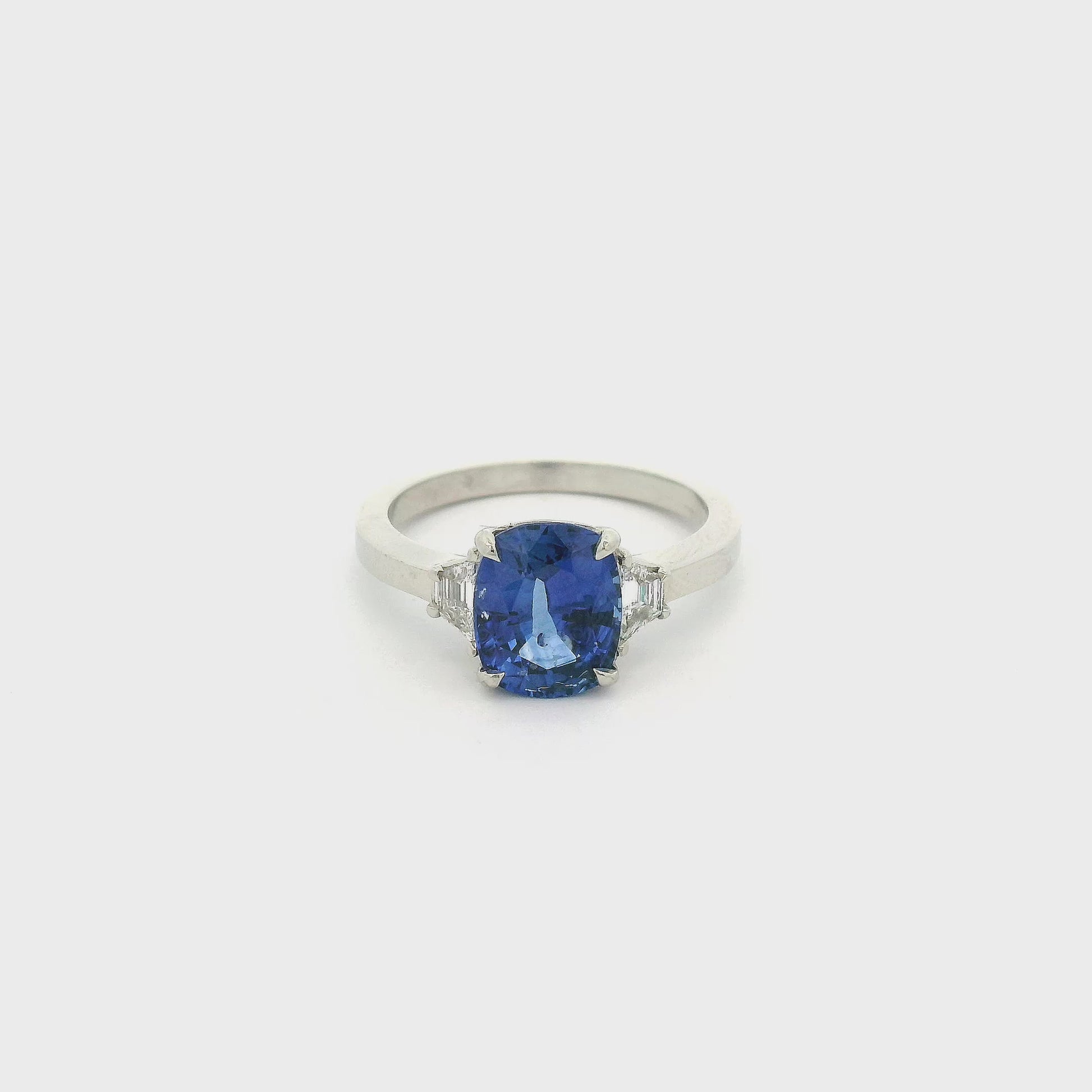 A White Gold Ring with a prong set cushion cut natural Sapphire in the center with two trillion cut Diamonds at Forever Rox Fine Jewelry, Lake Tahoes Best Jewelry Store