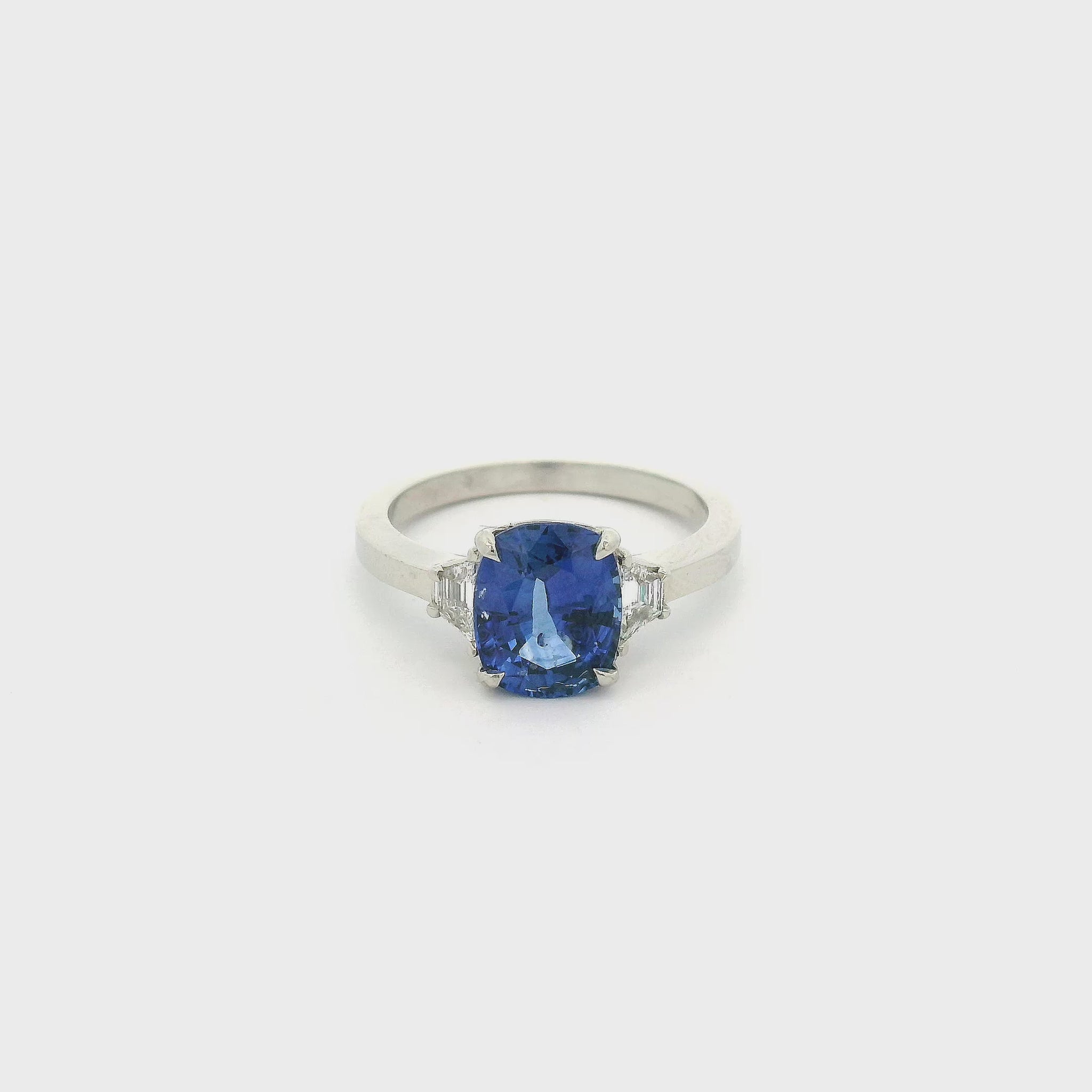 A White Gold Ring with a prong set cushion cut natural Sapphire in the center with two trillion cut Diamonds at Forever Rox Fine Jewelry, Lake Tahoes Best Jewelry Store