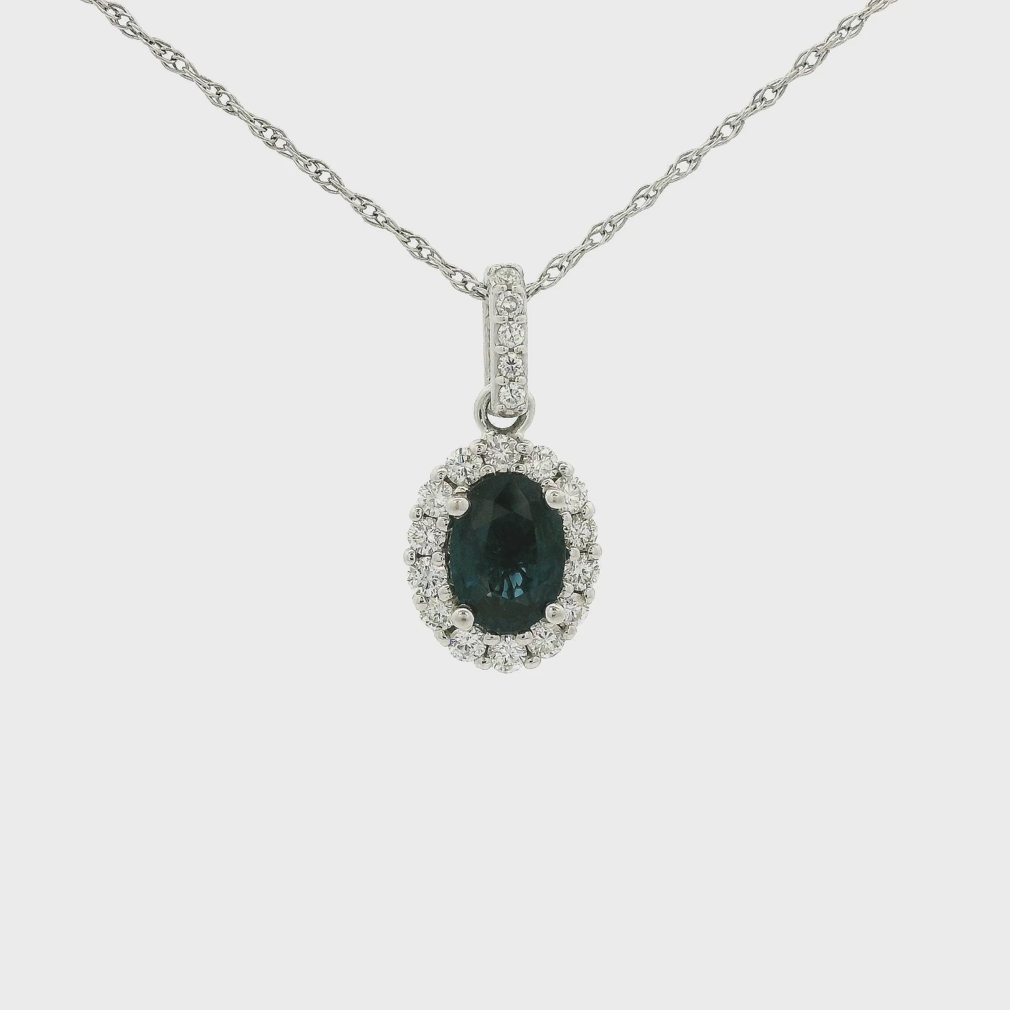 A White Gold Pendant with a bezel set oval cut natural Sapphire in the center with a halo of diamonds and diamond bail at Forever Rox Fine Jewelry, Lake Tahoes Best Jewelry Store