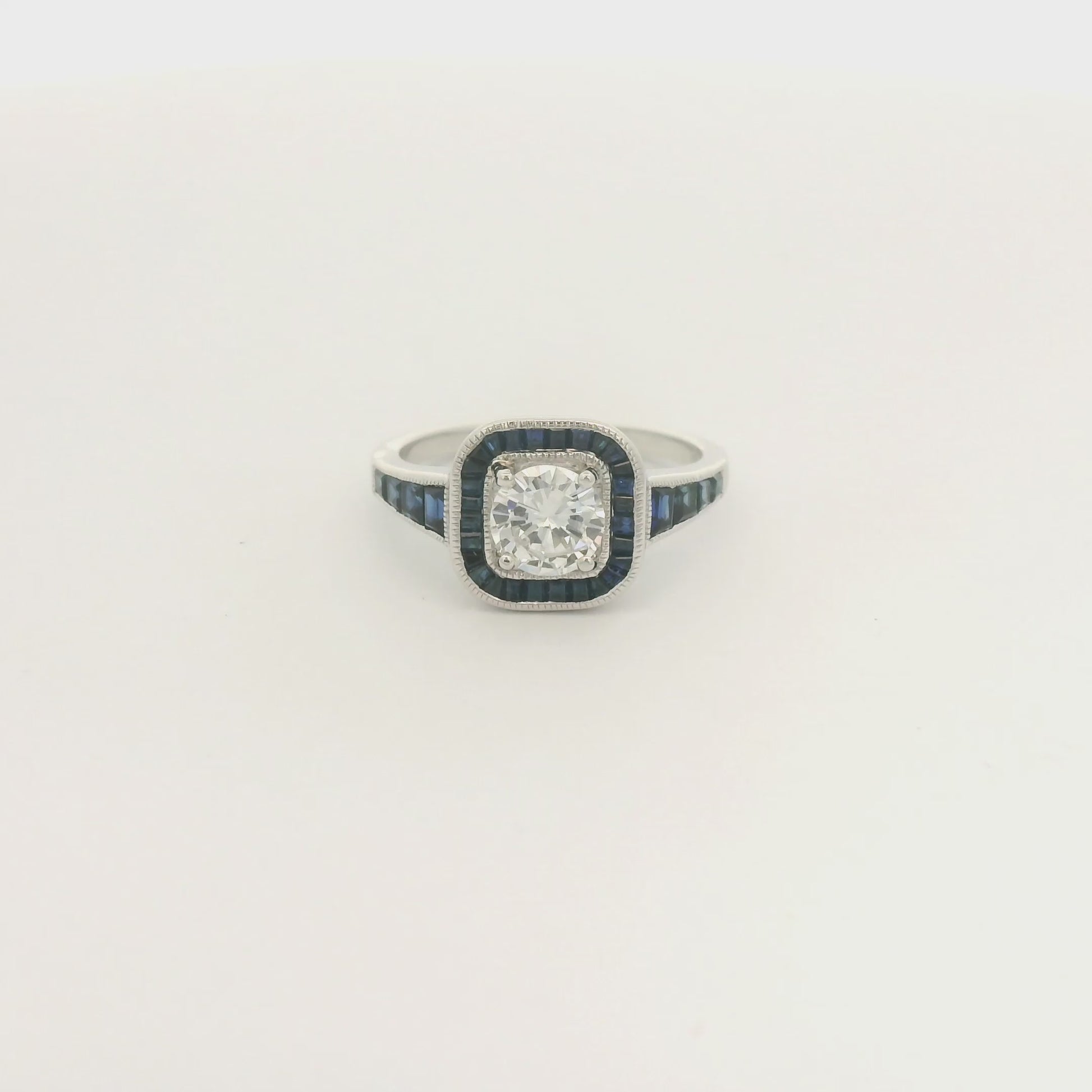 A White Gold Ring with a prong set round cut natural Diamond in the center with a halo of baguette cut blue sapphires and sapphires down shank at Forever Rox Fine Jewelry, Lake Tahoes Best Jewelry Store
